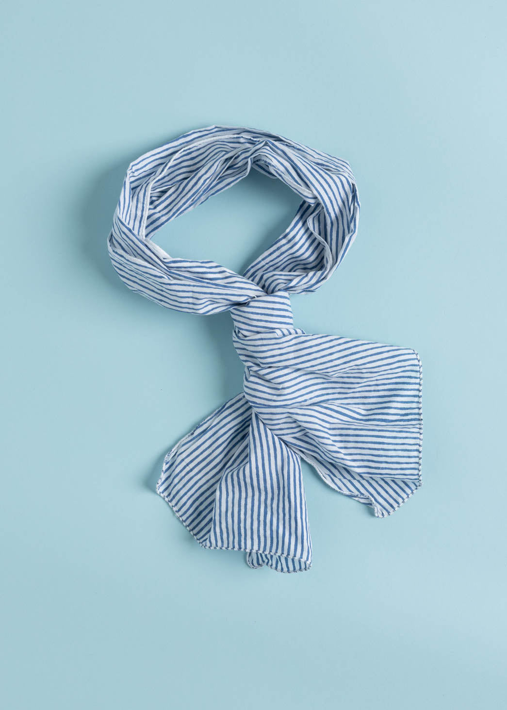 Menswear Stripe Skinny Blue scarf made from organic cotton, featuring vibrant block prints and a hand-loomed design, perfect for versatile styling.