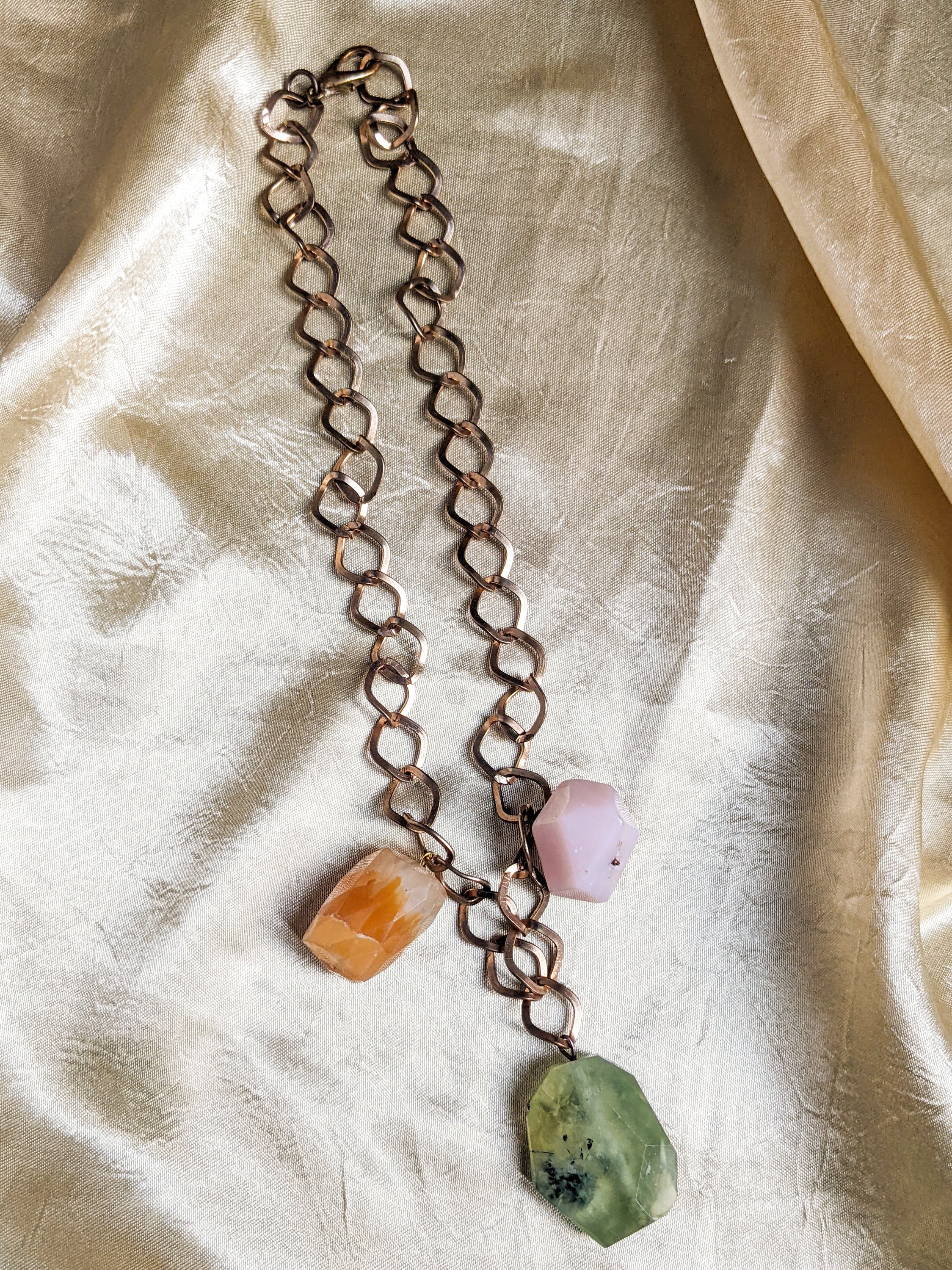 A beautiful semi-precious stones necklace featuring a luxurious golden chain, showcasing vibrant stones in various colors.