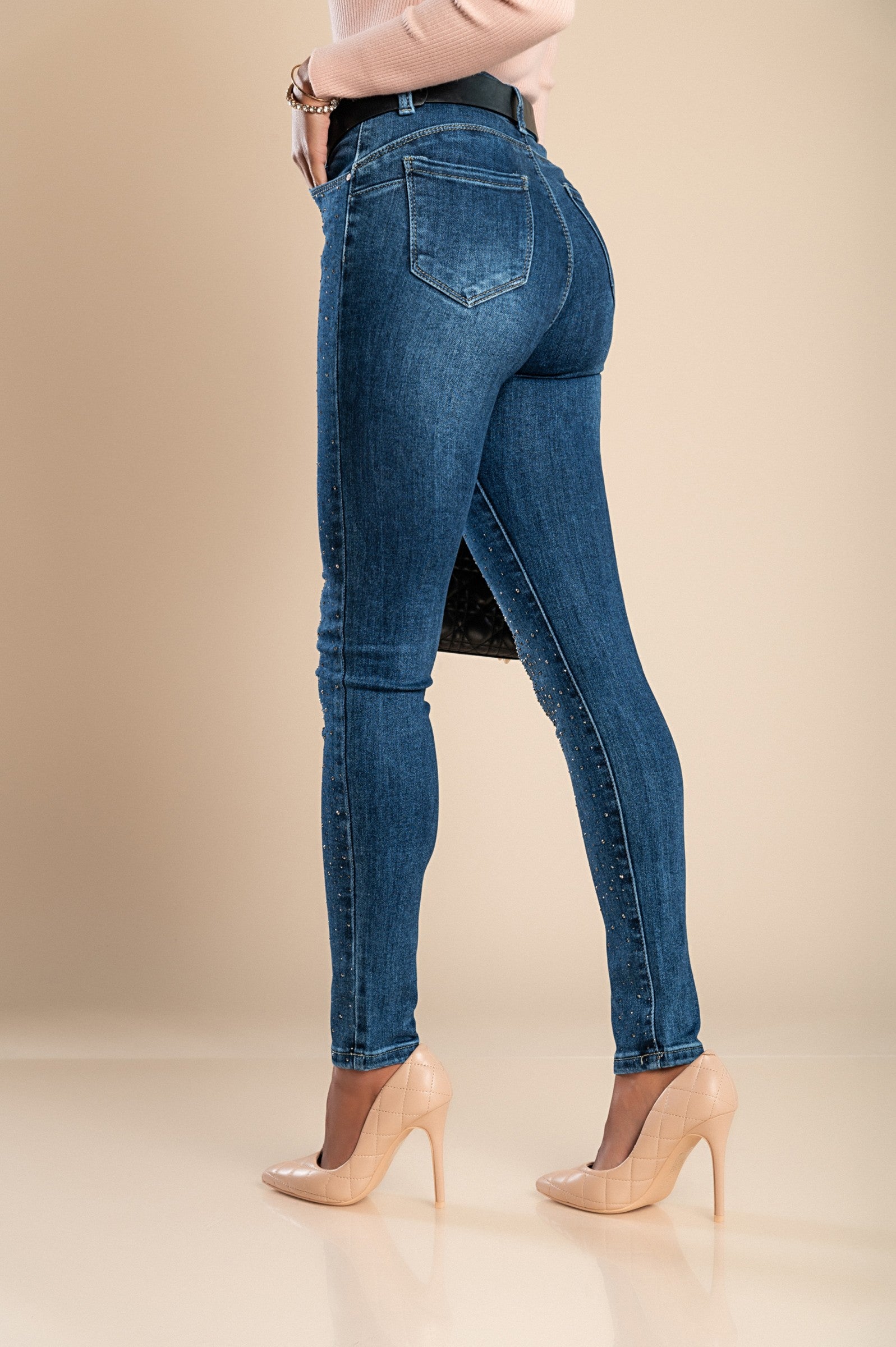 Stylish blue sequined skinny jeans with front and back pockets, featuring a button and zipper closure.