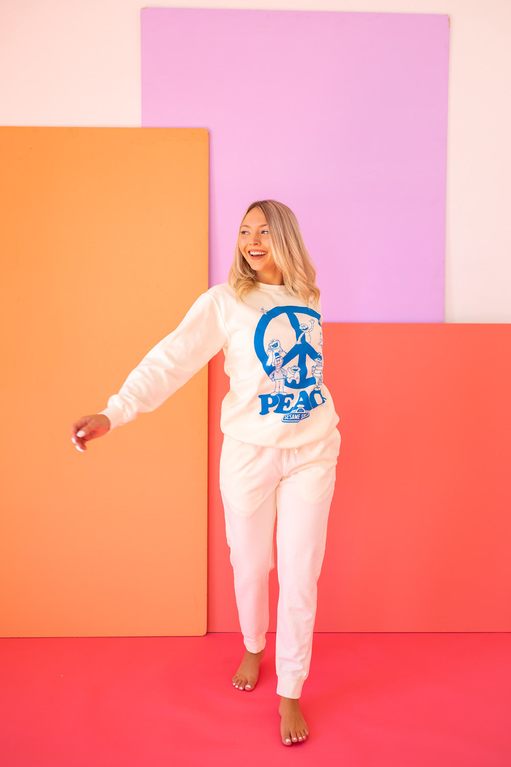 Ivory Sesame Street Peace Sweatshirt featuring bold graphics, made from 100% upcycled cotton, available in sizes S-XL.