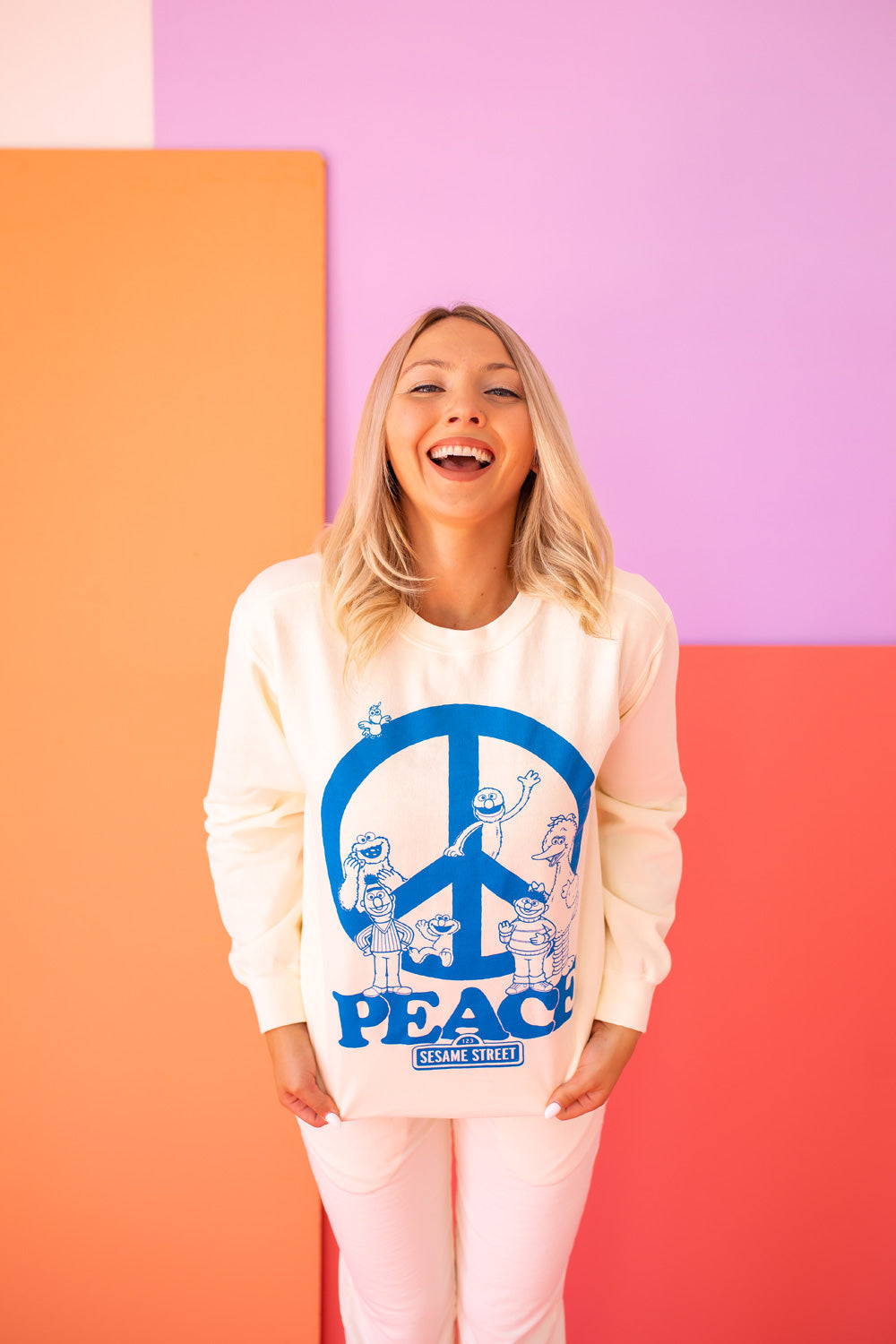 Ivory Sesame Street Peace Sweatshirt featuring bold graphics, made from 100% upcycled cotton, available in sizes S-XL.