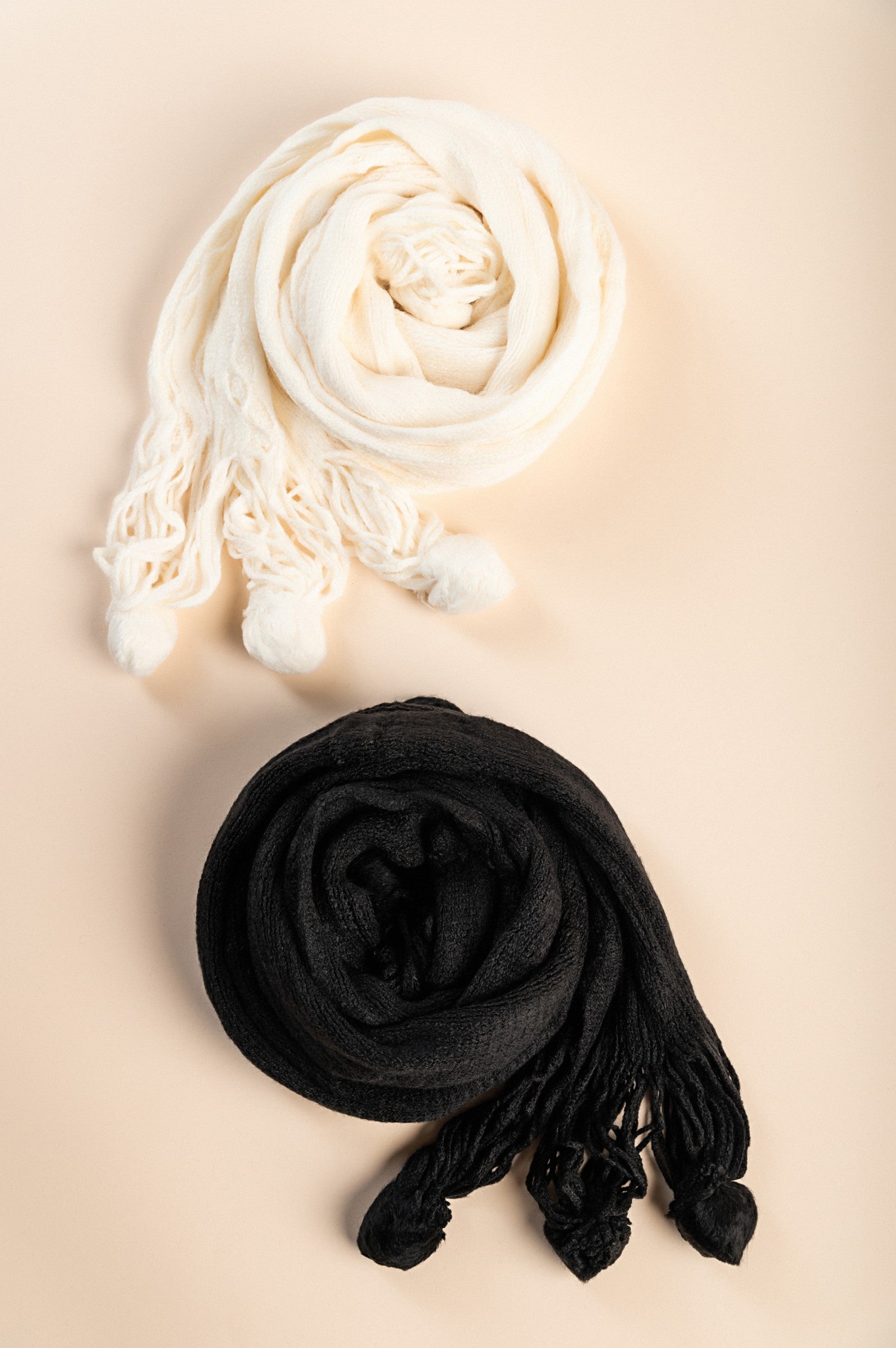 Set of 2 knitted scarves in white and black, showcasing their soft texture and elegant design.