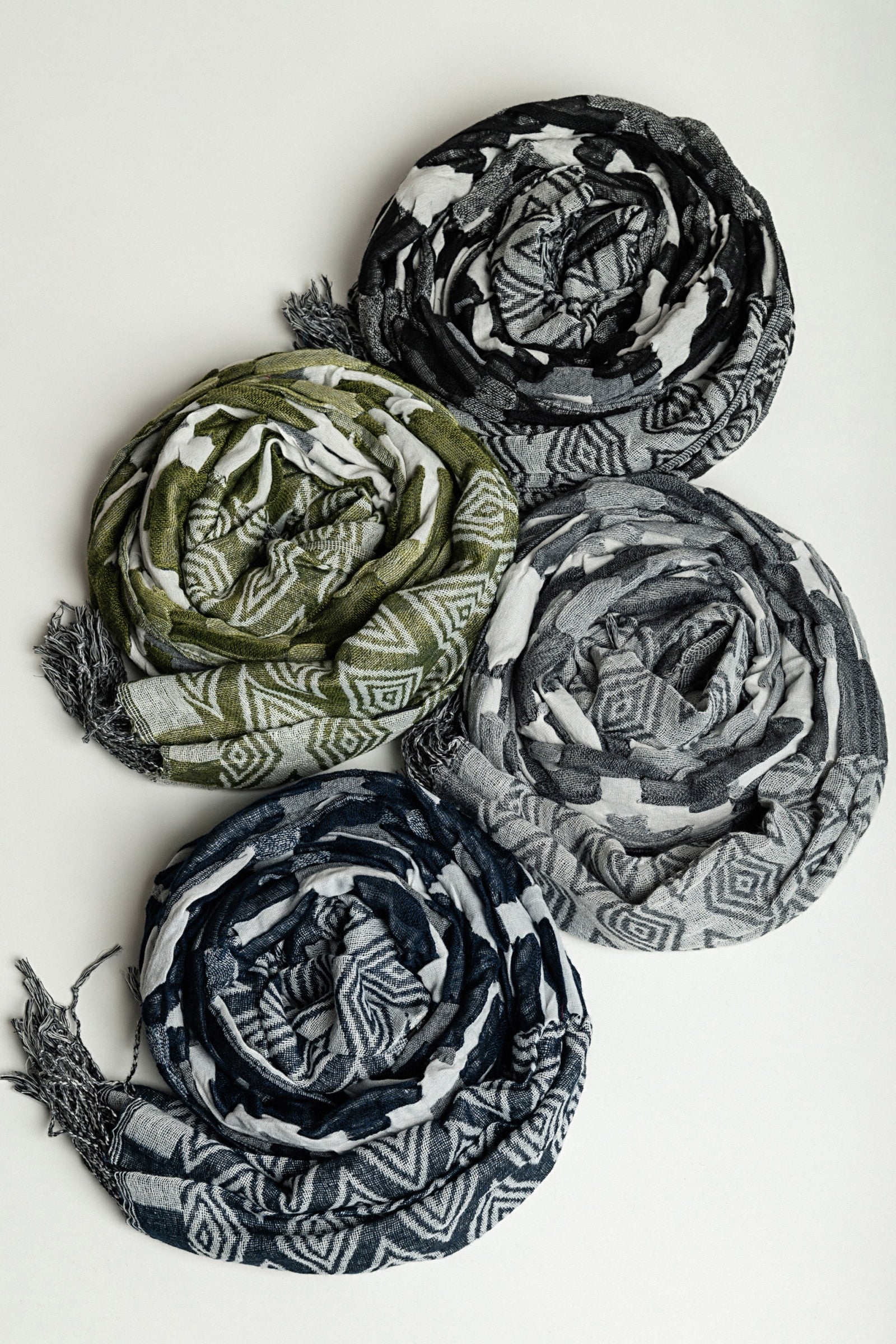 Set of 4 multicolored scarves in black, grey, blue, and green, made from 100% viscose, elegantly displayed.