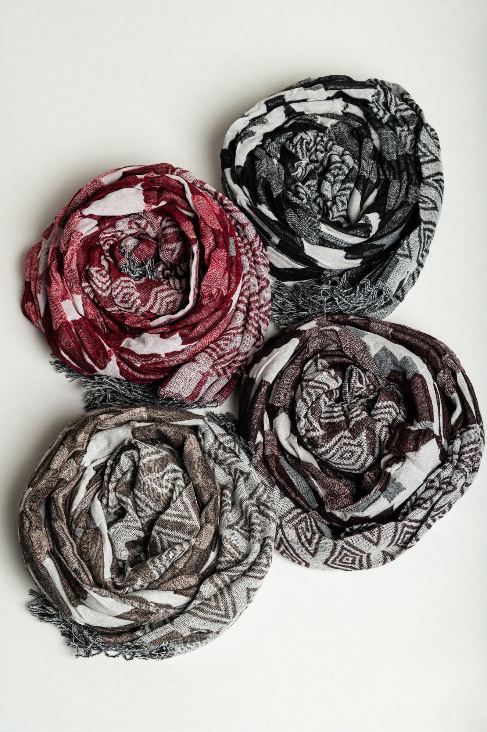 Set of 4 multicolored scarves in black, fuchsia, brown, and beige, made from 100% viscose, elegantly displayed.