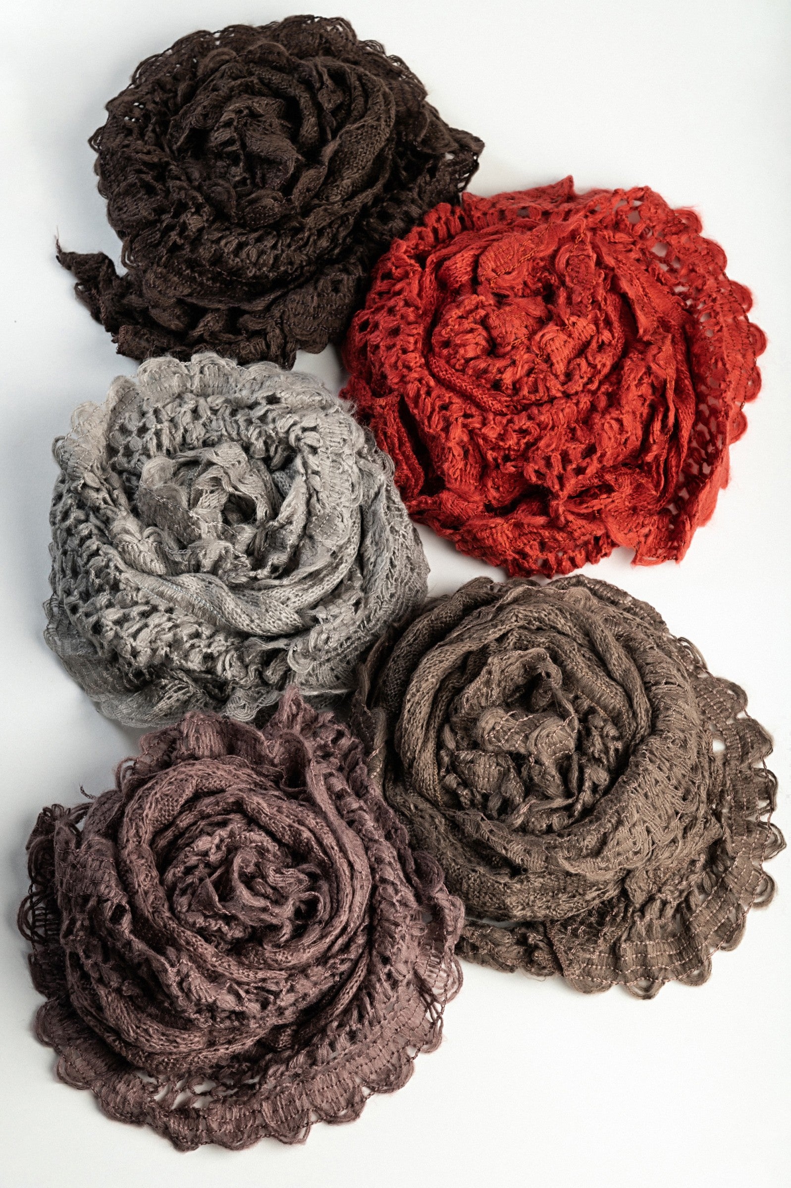 A vibrant set of 5 knitted scarves in dark brown, brick, olive, purple, and light gray, showcasing their soft texture and colors.