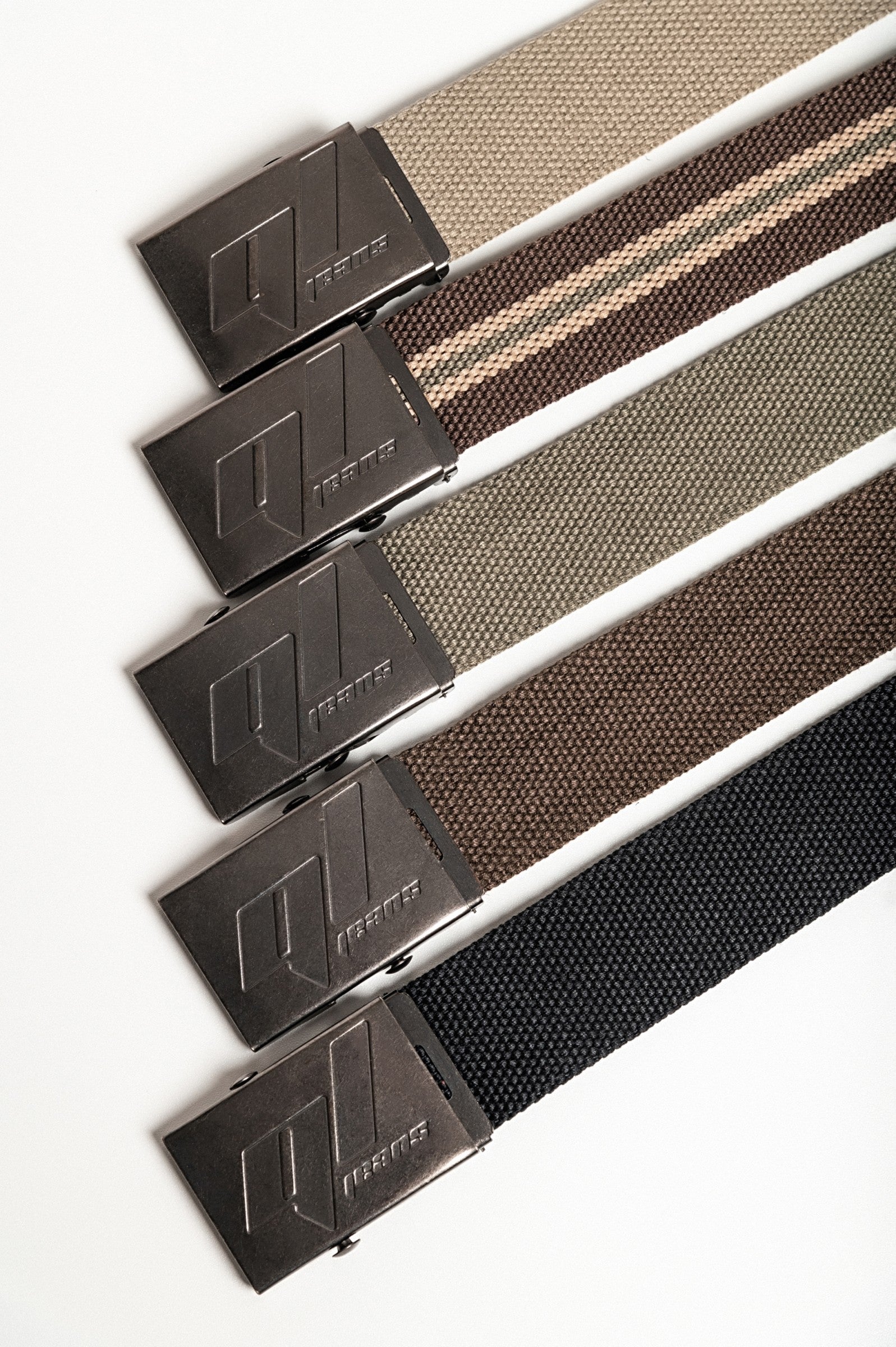 Set of five stylish belts in various colors including green, black, olive, brown, and striped, featuring a metal buckle with engraving.