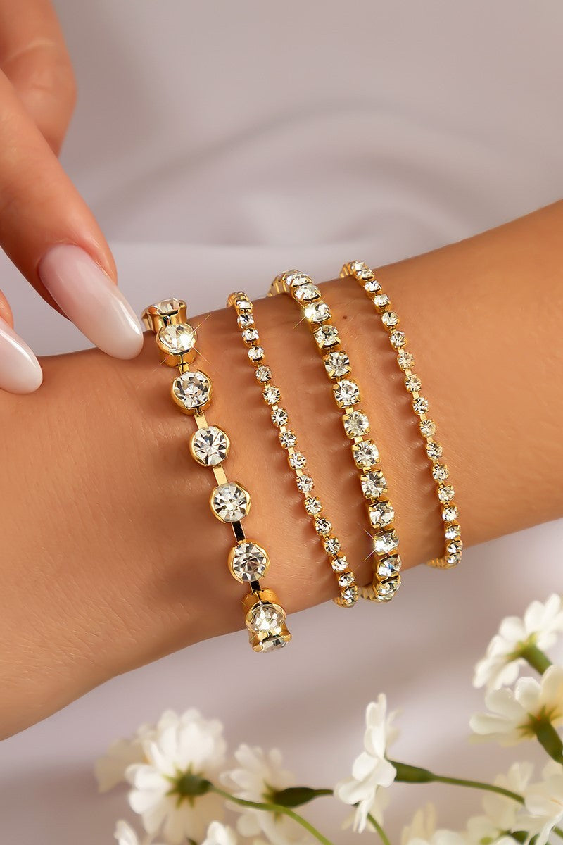 A set of four gold-tone rhinestone bracelets featuring decorative stones and a metal lobster clasp, elegantly displayed.