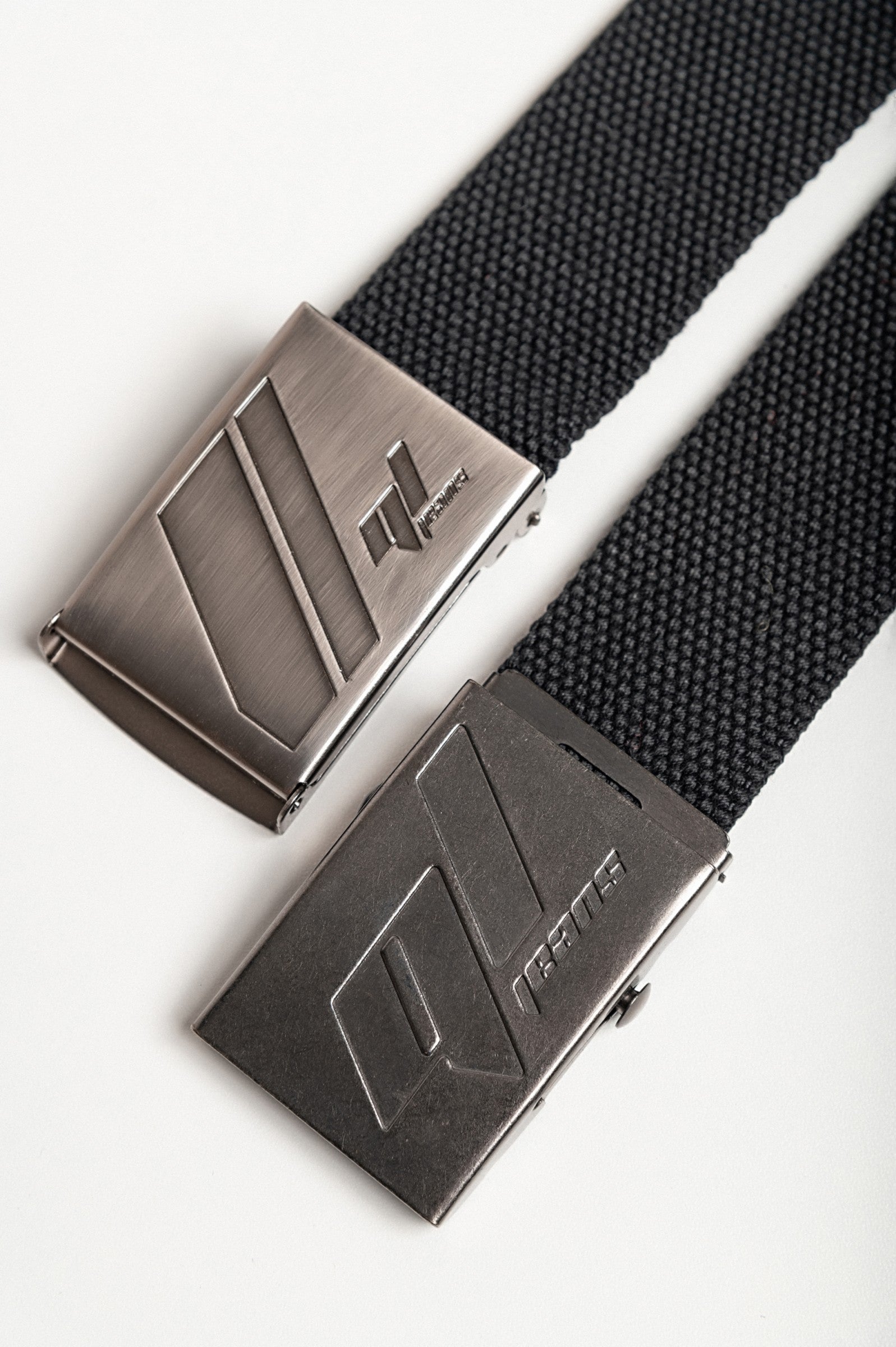 Set of two black trouser belts featuring metal buckles, showcasing their adjustable length and robust material.