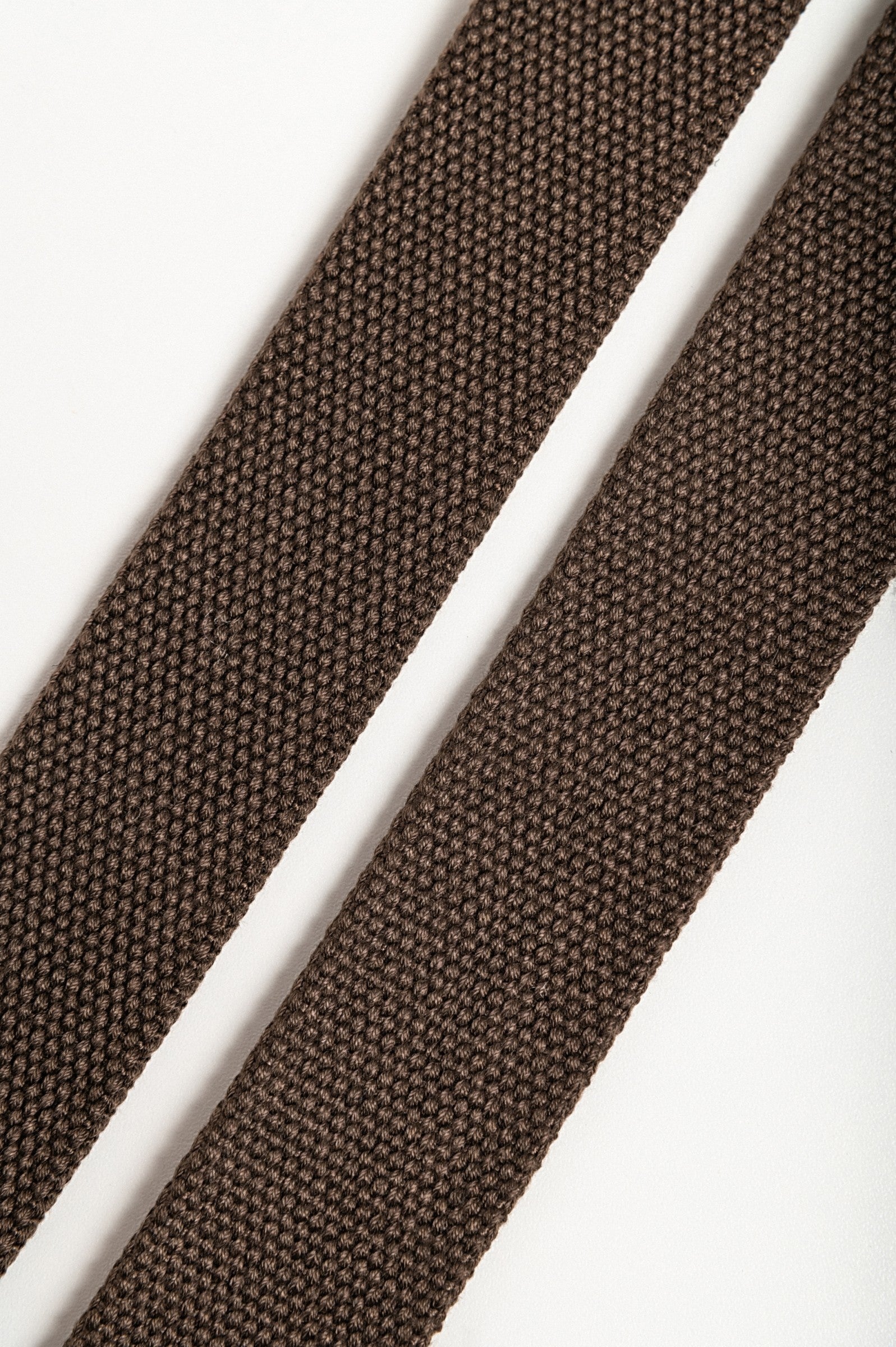 Set of two brown trouser belts featuring durable metal buckles, showcasing their adjustable length and robust material.