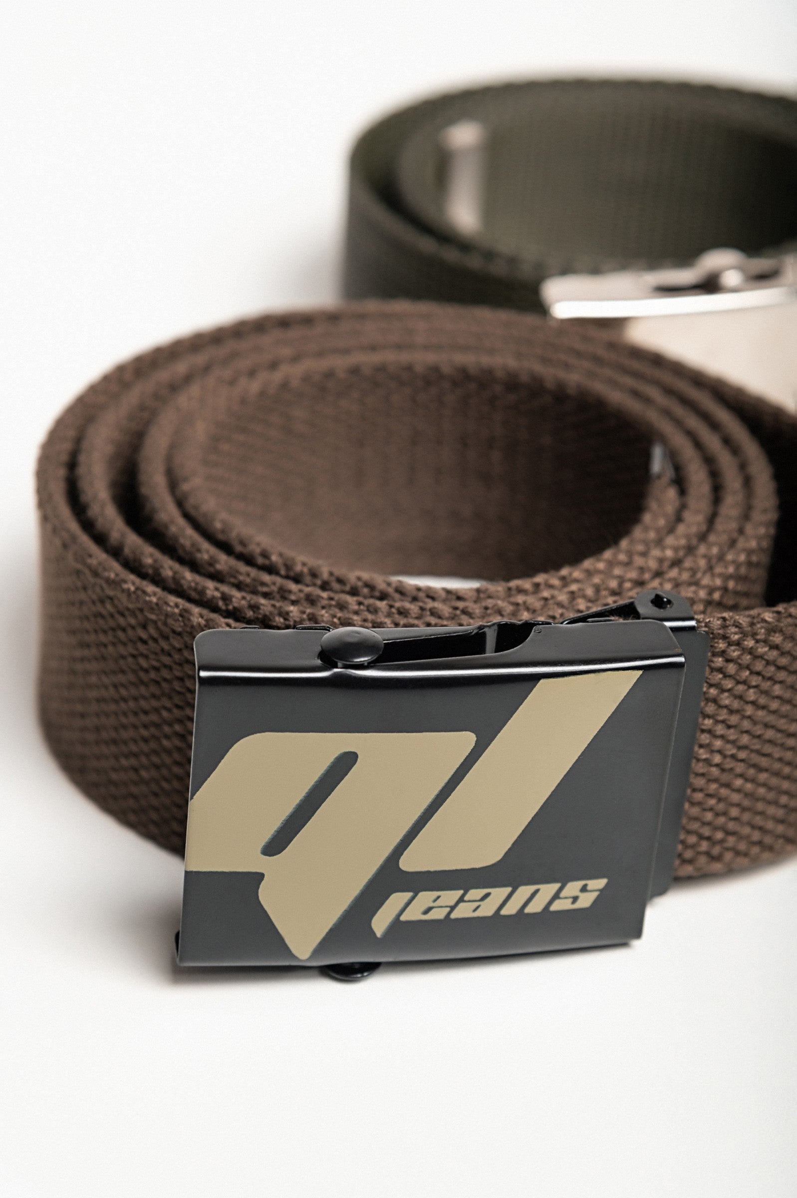 Set of two multicolored belts in brown and green with metal buckles, showcasing their adjustable lengths and durable material.