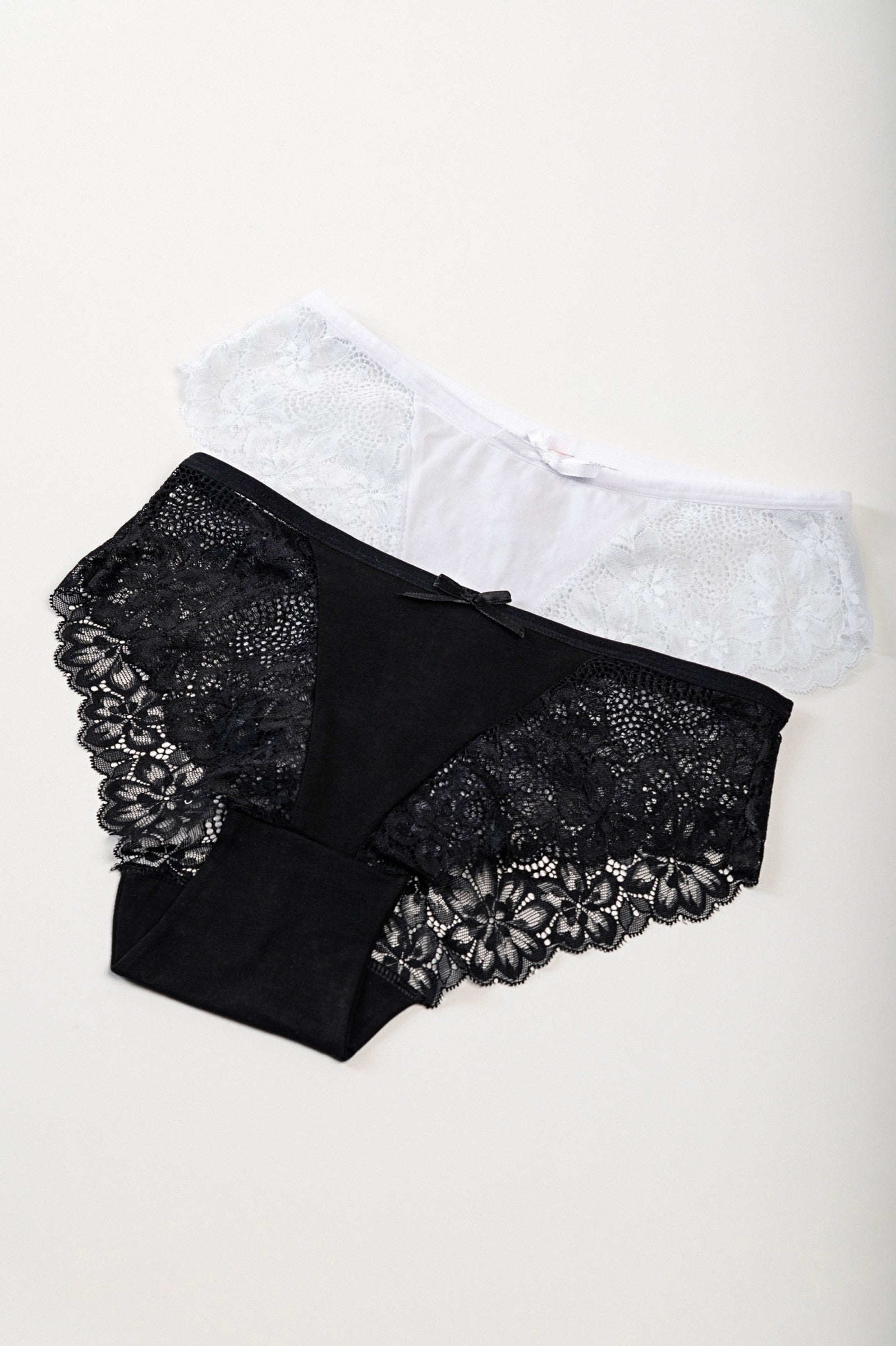 Set of two lace panties in black and white, showcasing elegant design and high-quality fabric.