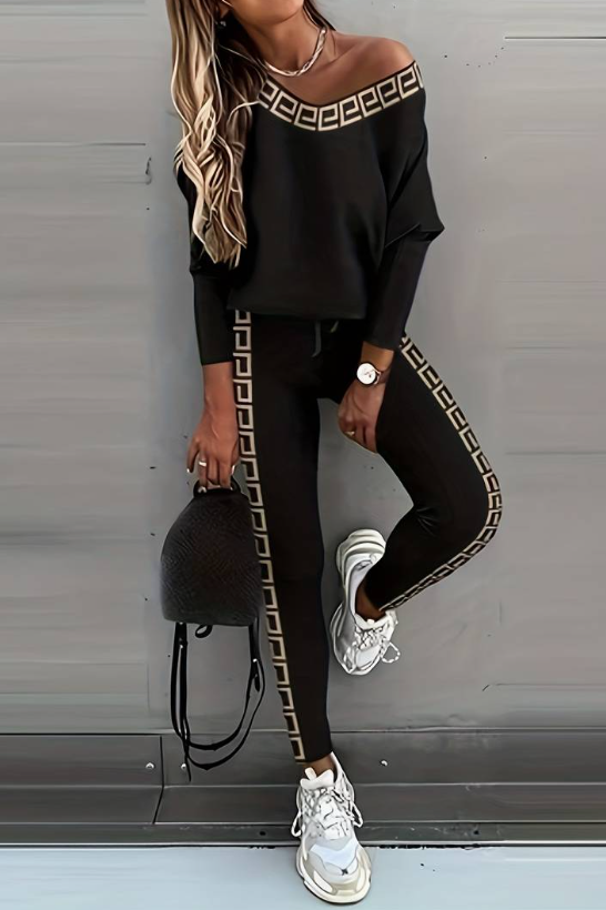 A stylish black set featuring a geometric print top with a boat neckline and long sleeves, paired with long pants that have an elastic waist.