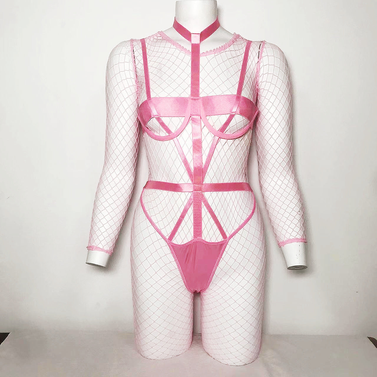 A stylish pink fishnet jumpsuit featuring cutout designs and lace details, perfect for intimate occasions.