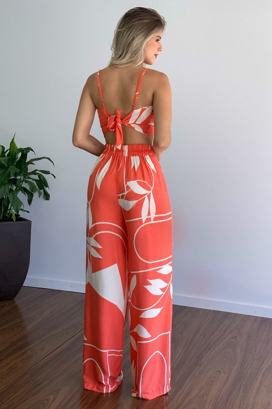 A stylish model wearing a sexy summer two-piece pant set featuring a sleeveless crop top and elasticized waist pants.