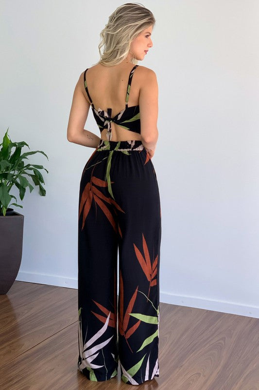 A stylish model wearing a sexy summer two-piece pant set featuring a sleeveless crop top and elasticized waist pants.