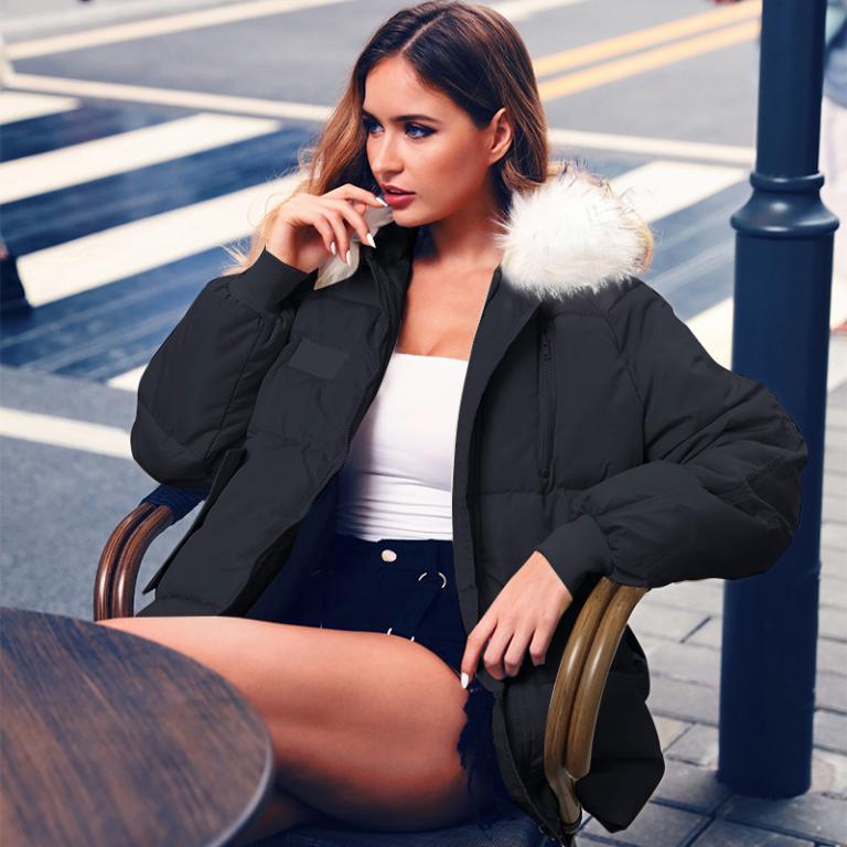 A stylish female model wearing a sexy winter warm hooded down jacket with a fur collar, showcasing its slim fit and zipper closure.