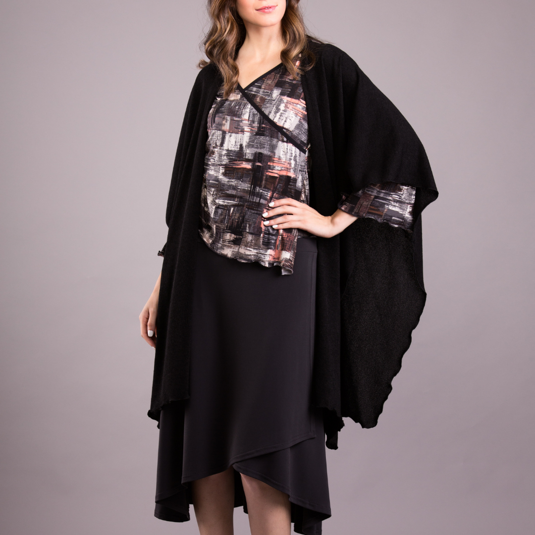 A cozy Mirage Knit Shawl draped elegantly over a mannequin, showcasing its soft knit texture and versatile design.