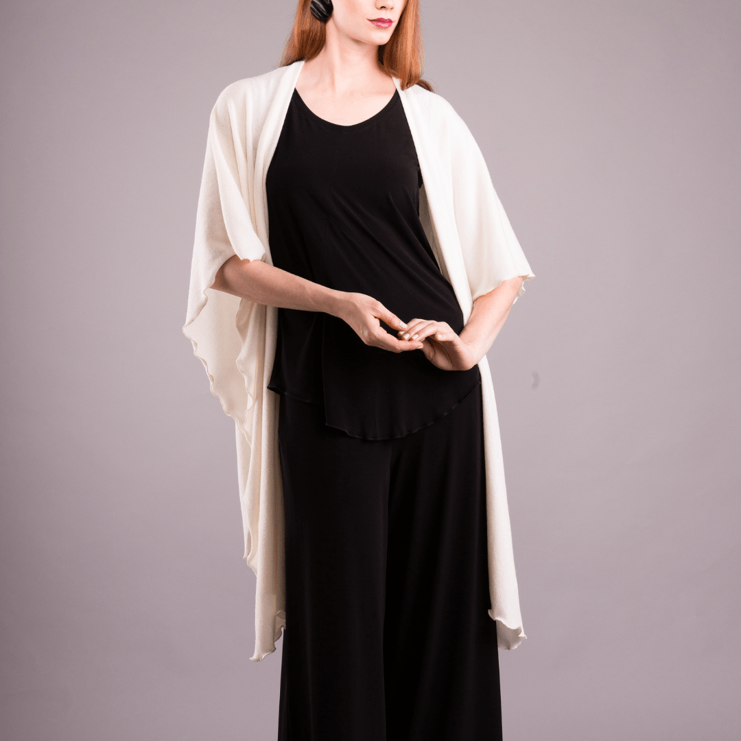 A cozy Mirage Knit Shawl draped elegantly over a mannequin, showcasing its soft knit texture and versatile design.