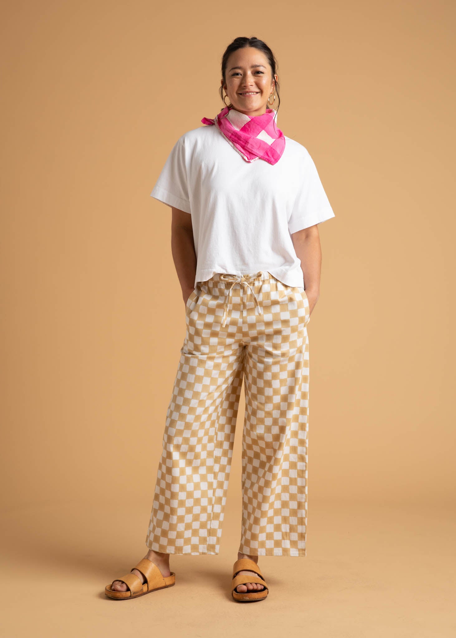 A pair of Shore Pants in Checkerboard Natural pattern, showcasing a modern cropped length and relaxed fit, made from organic cotton.