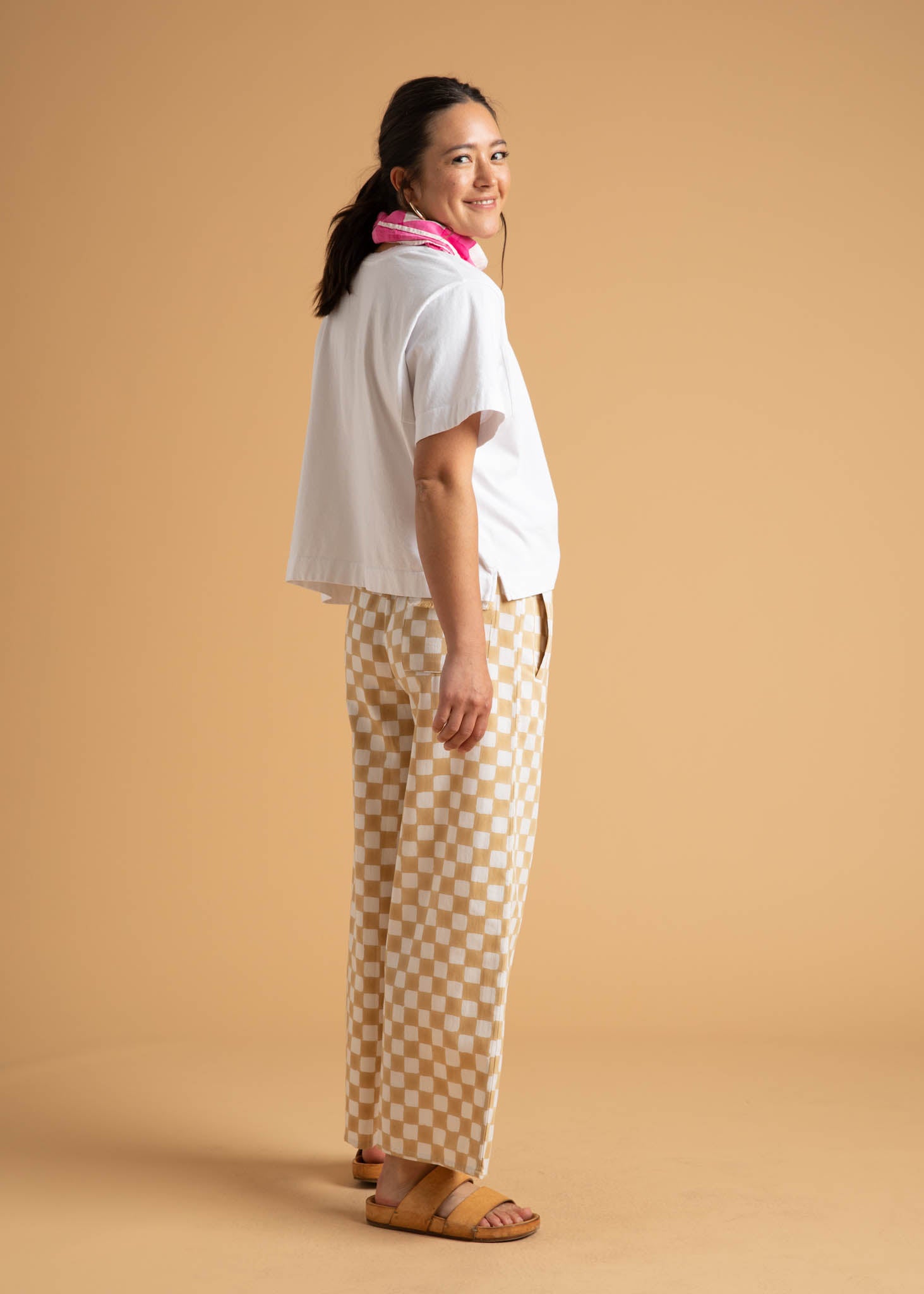 A pair of Shore Pants in Checkerboard Natural pattern, showcasing a modern cropped length and relaxed fit, made from organic cotton.