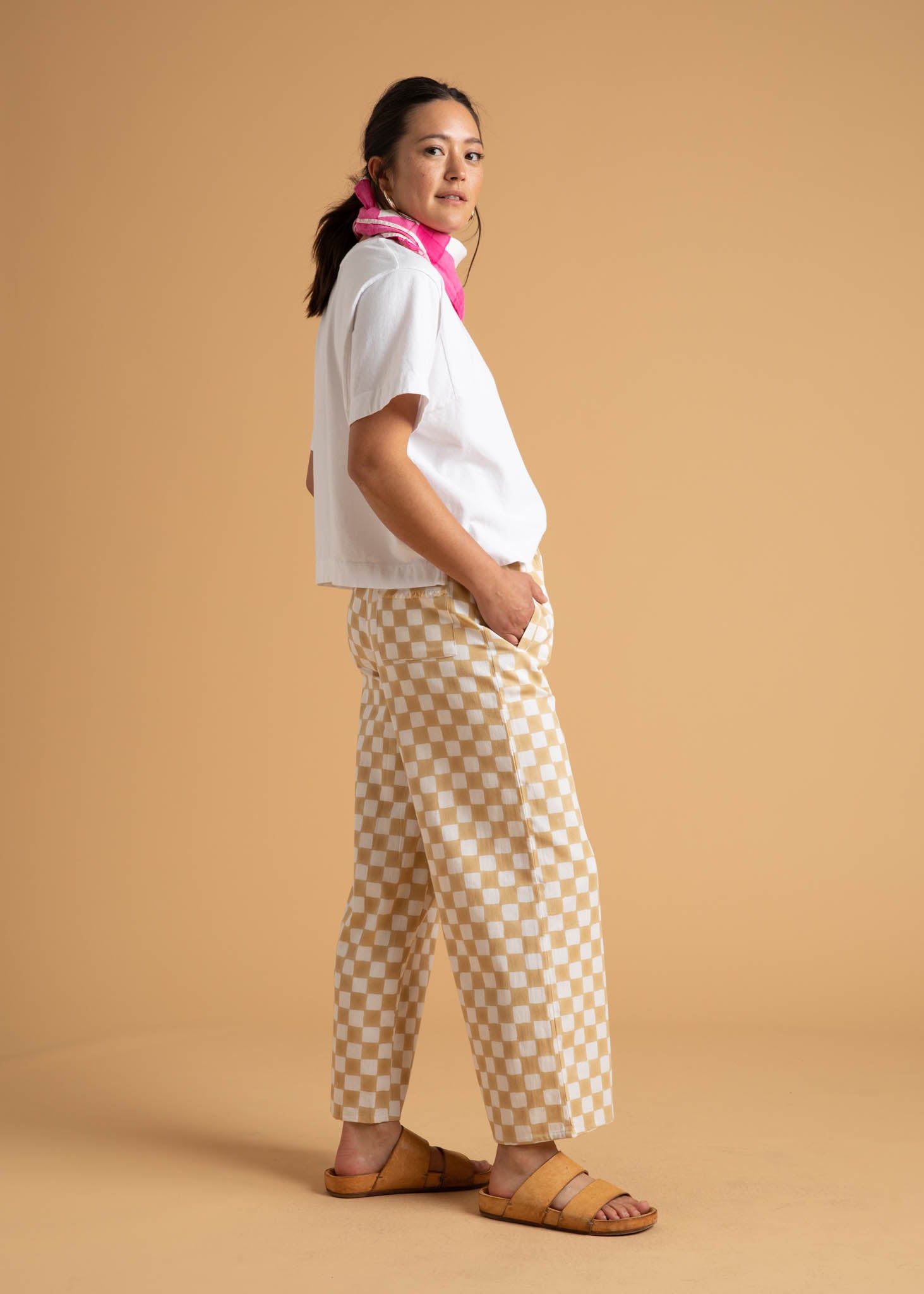 A pair of Shore Pants in Checkerboard Natural pattern, showcasing a modern cropped length and relaxed fit, made from organic cotton.