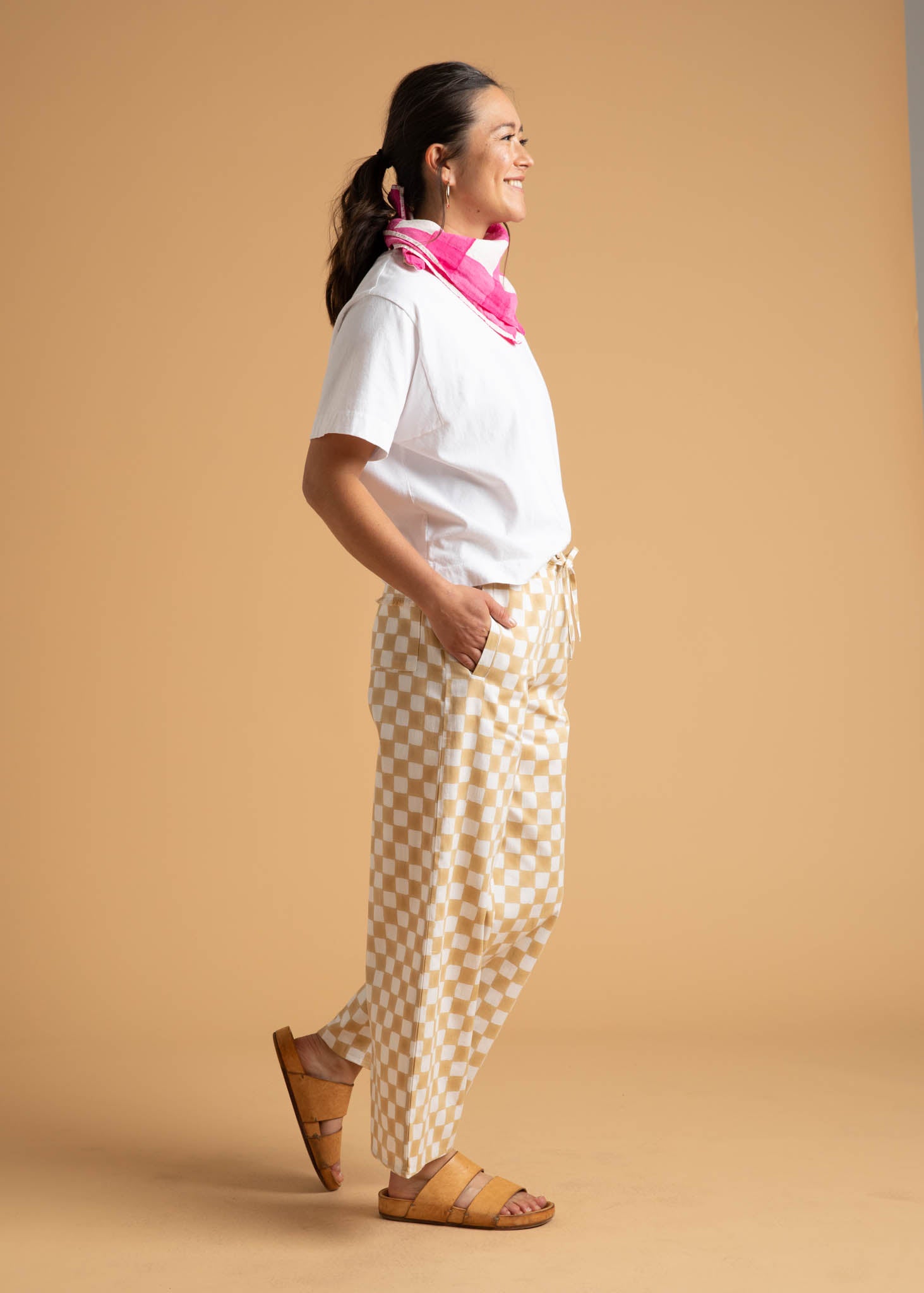 A pair of Shore Pants in Checkerboard Natural pattern, showcasing a modern cropped length and relaxed fit, made from organic cotton.