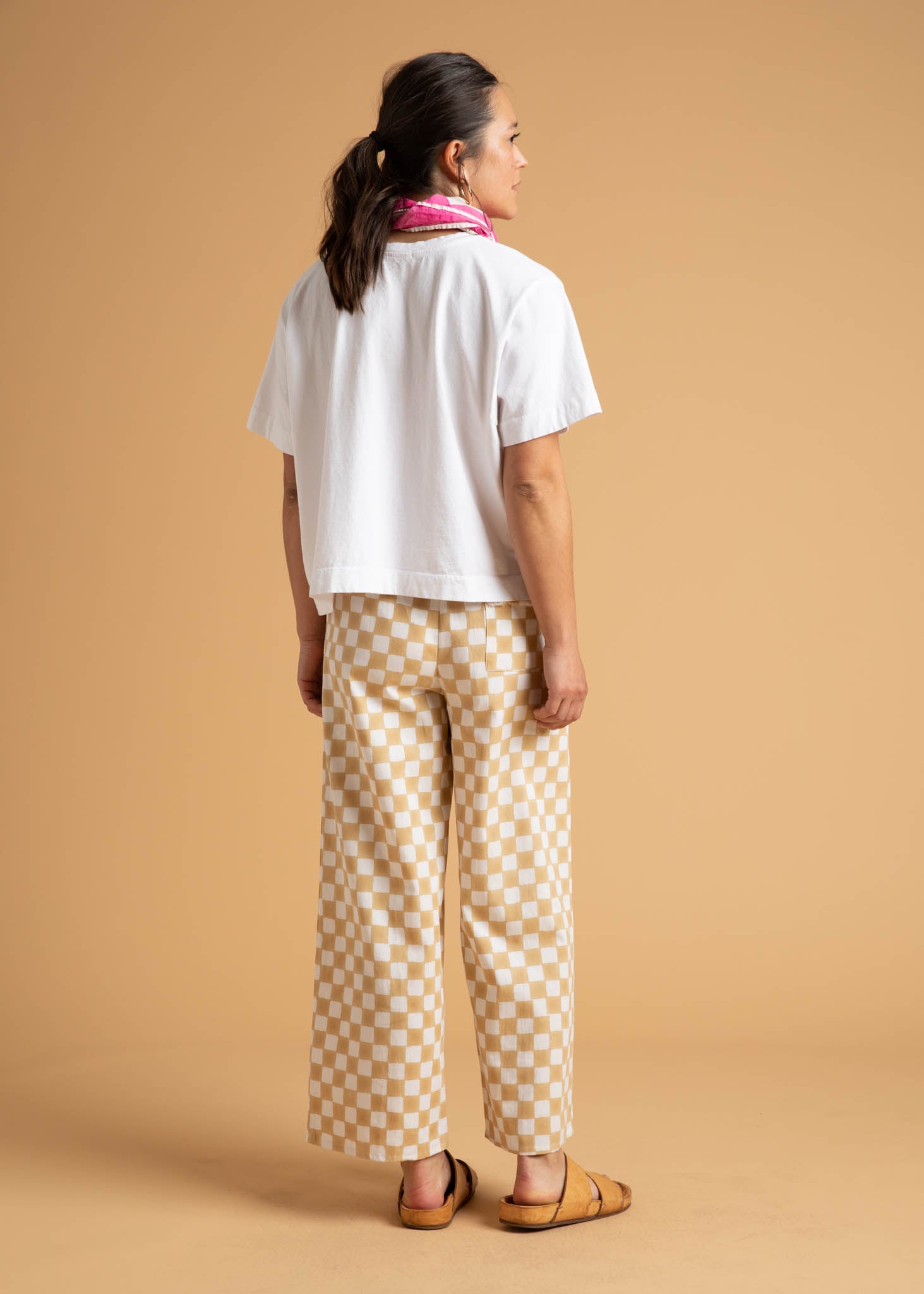 A pair of Shore Pants in Checkerboard Natural pattern, showcasing a modern cropped length and relaxed fit, made from organic cotton.