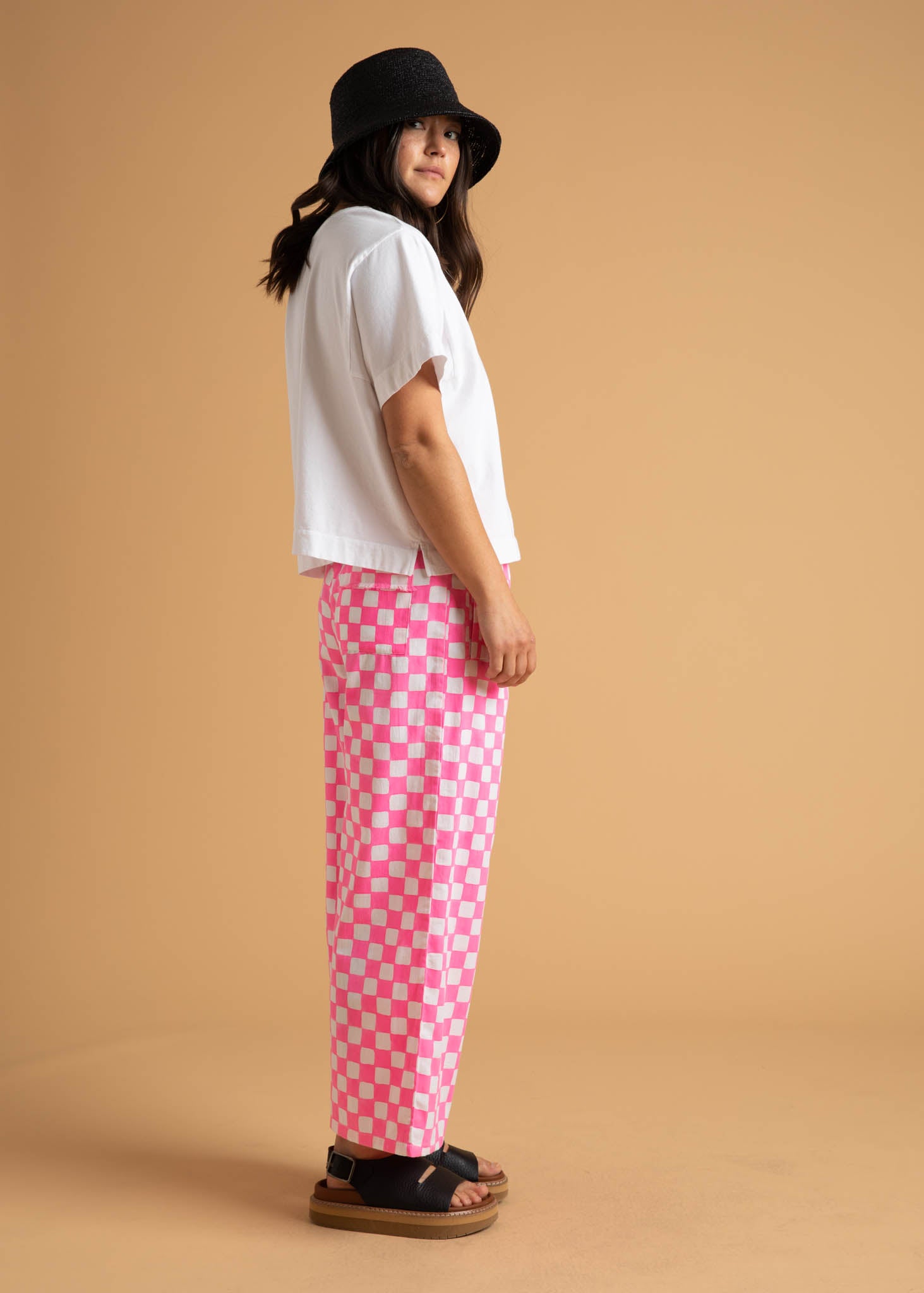 Shore Pant in Checkerboard Neon Pink, featuring a modern cropped length and relaxed fit, made from organic cotton with stylish pockets.