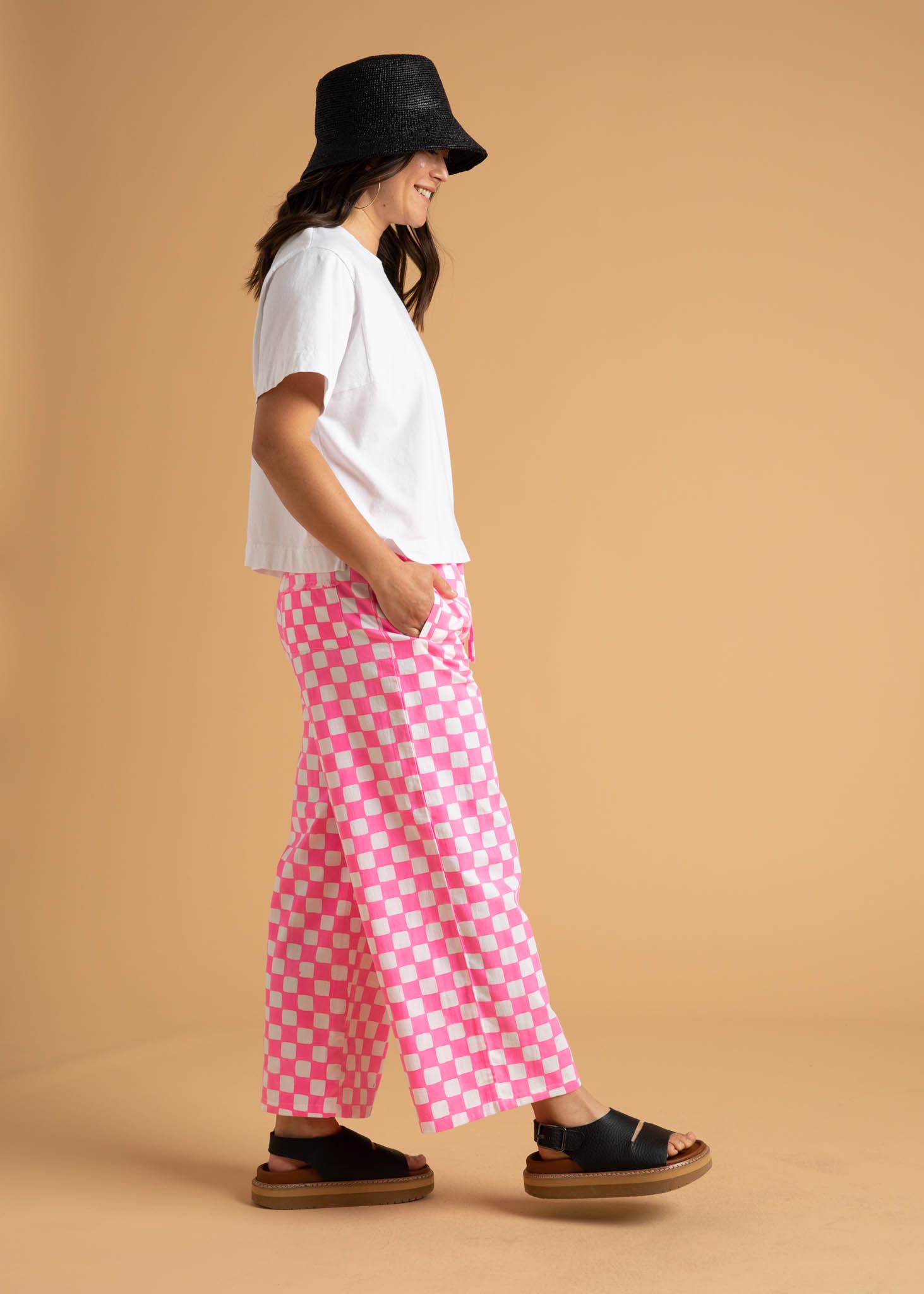 Shore Pant in Checkerboard Neon Pink, featuring a modern cropped length and relaxed fit, made from organic cotton with stylish pockets.