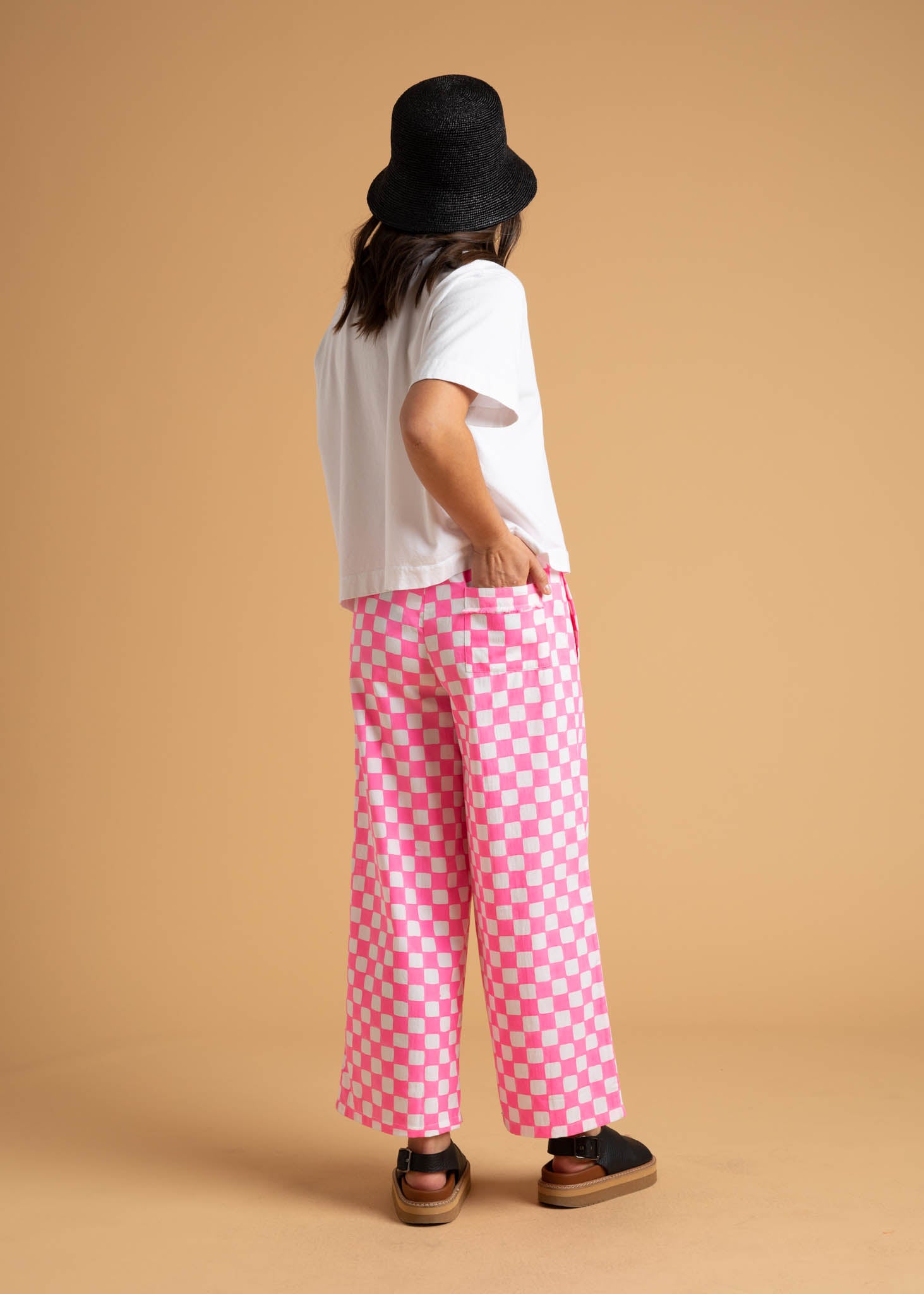 Shore Pant in Checkerboard Neon Pink, featuring a modern cropped length and relaxed fit, made from organic cotton with stylish pockets.