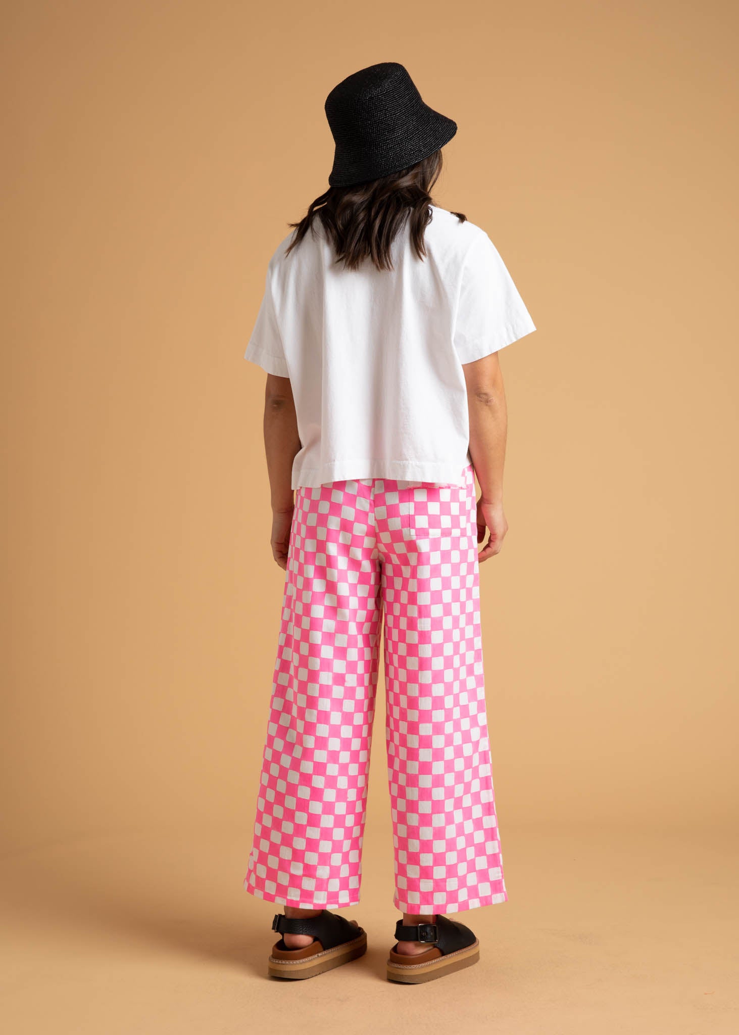 Shore Pant in Checkerboard Neon Pink, featuring a modern cropped length and relaxed fit, made from organic cotton with stylish pockets.