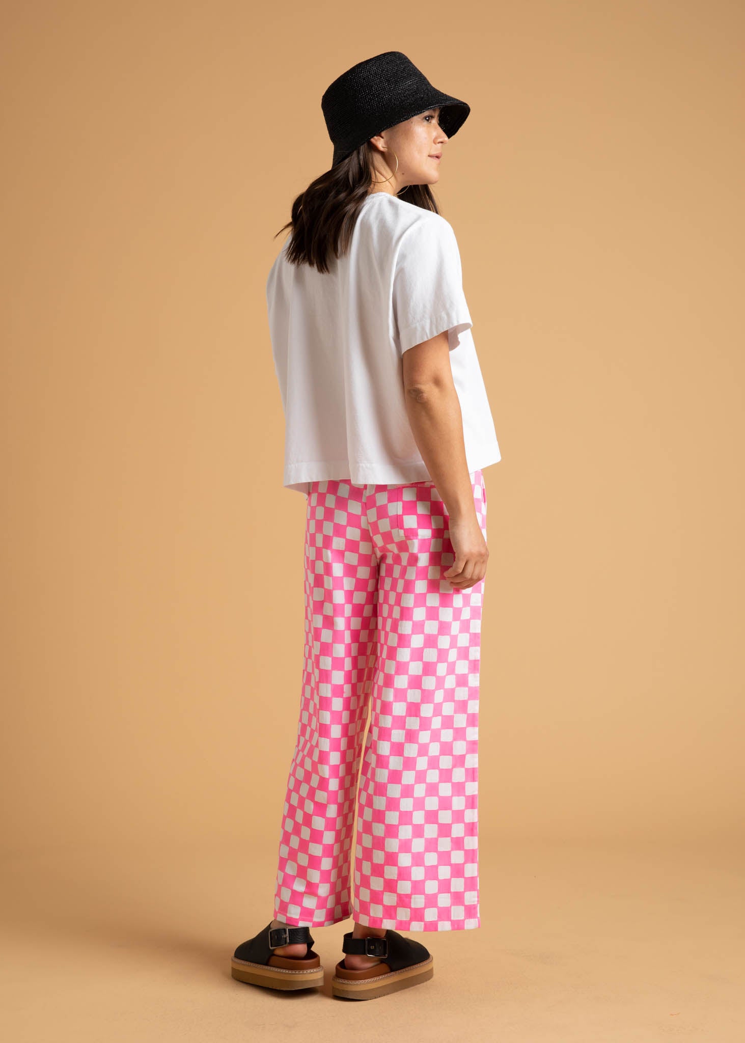 Shore Pant in Checkerboard Neon Pink, featuring a modern cropped length and relaxed fit, made from organic cotton with stylish pockets.