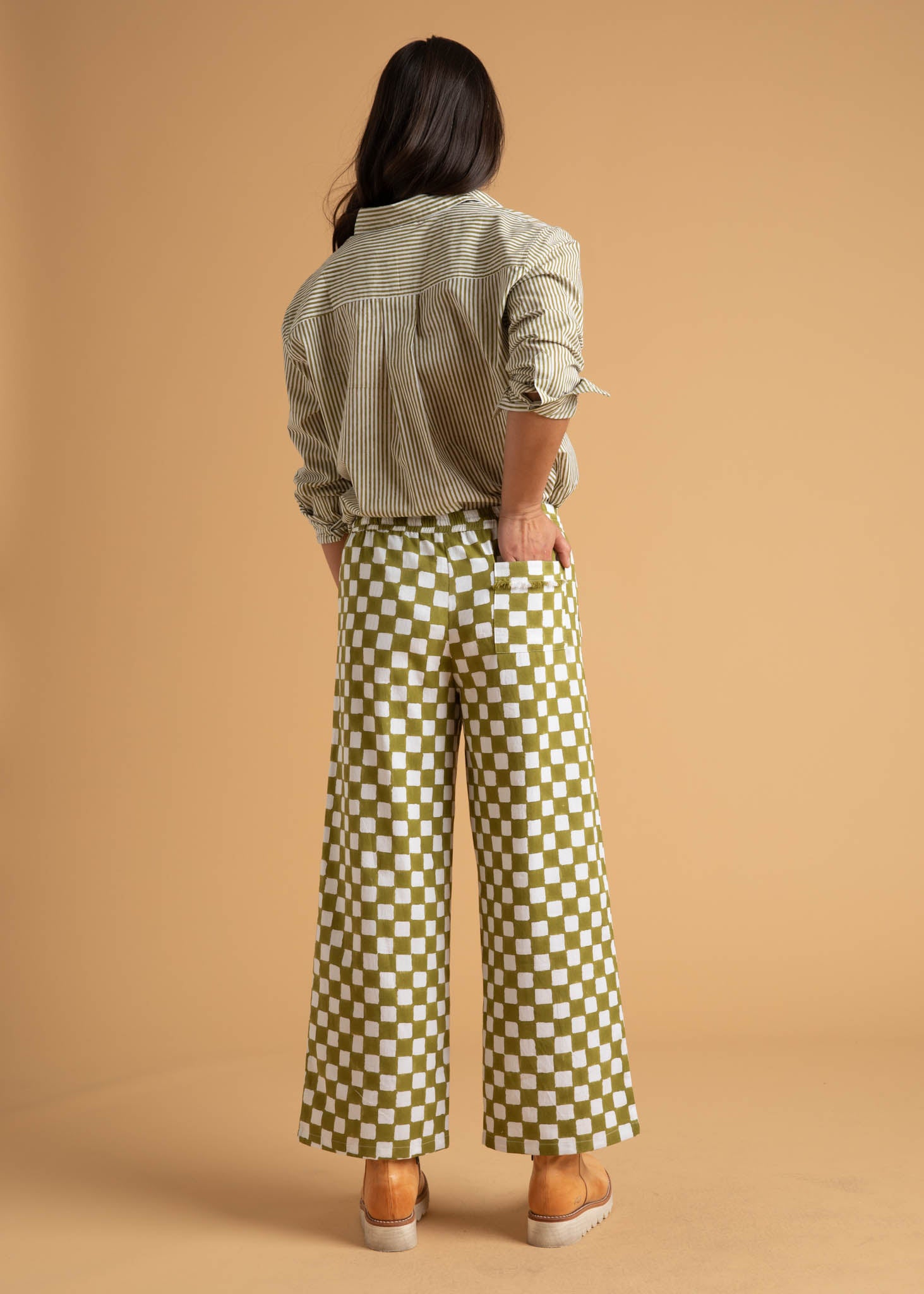 Shore Pant in Checkerboard Olive Oil, showcasing a modern cropped design with a relaxed fit and elastic waist, made from organic cotton.