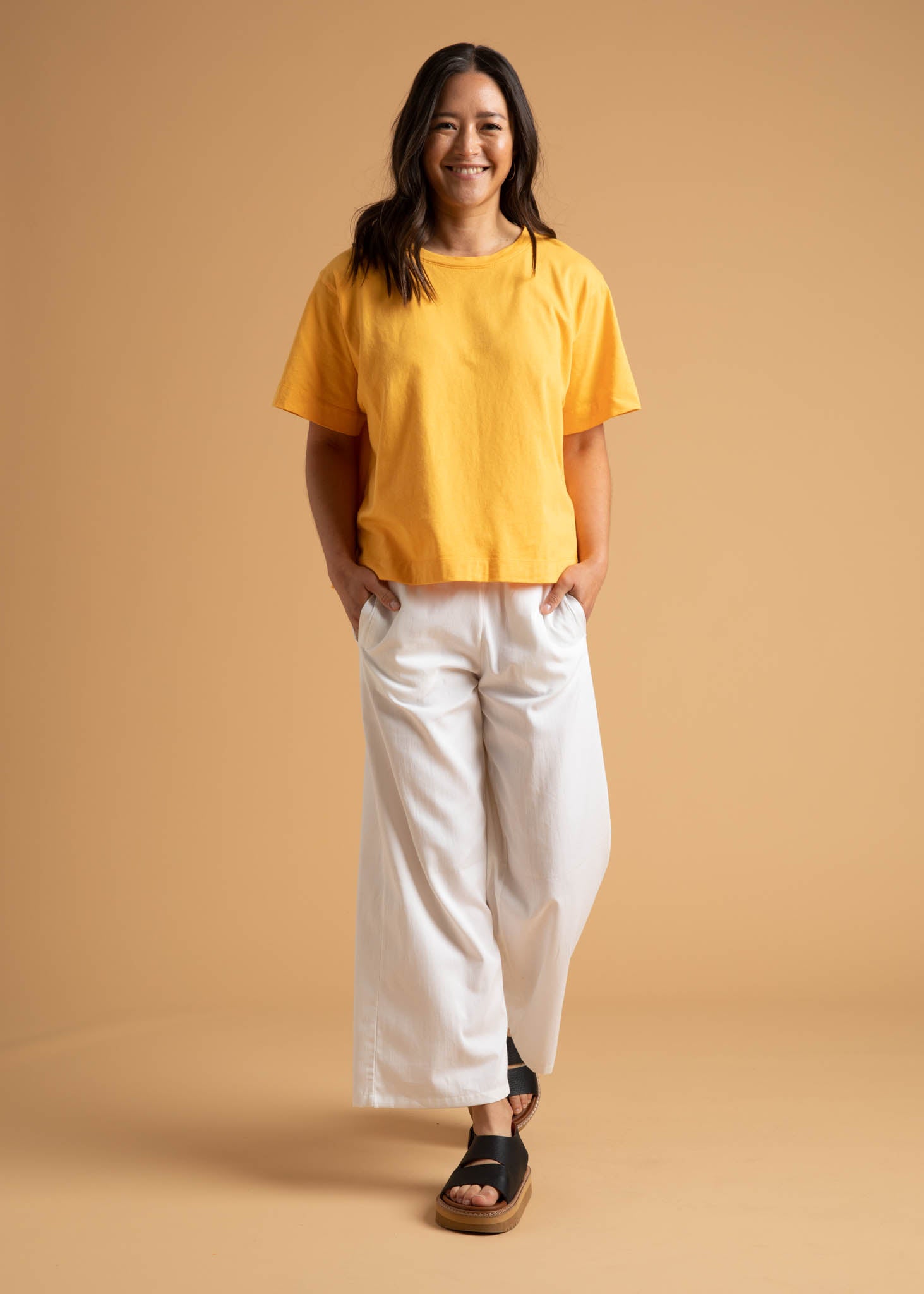 A pair of Shore Pants in Natural color, featuring a modern cropped length, relaxed fit, and elastic waist, displayed on a neutral background.