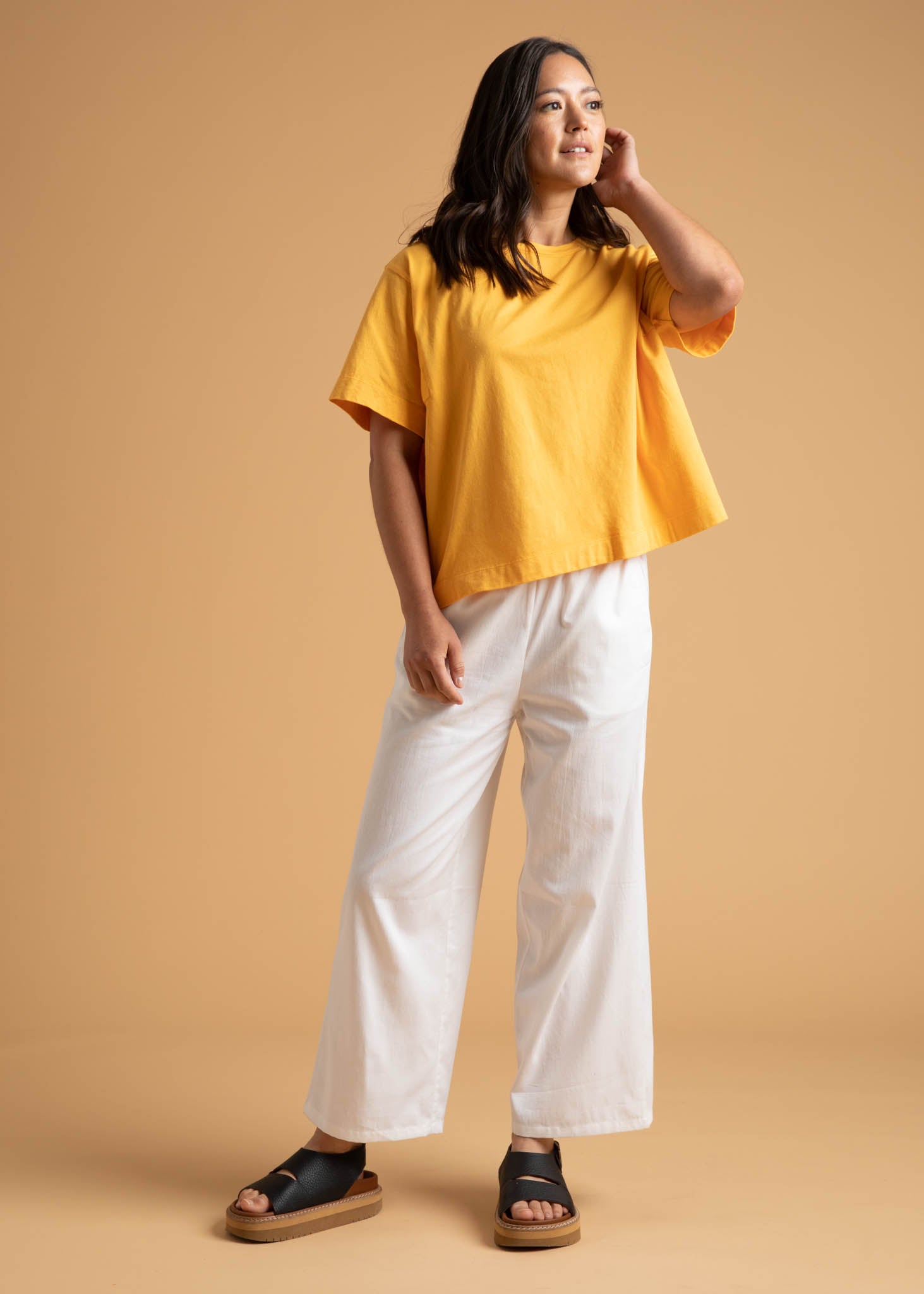 A pair of Shore Pants in Natural color, featuring a modern cropped length, relaxed fit, and elastic waist, displayed on a neutral background.