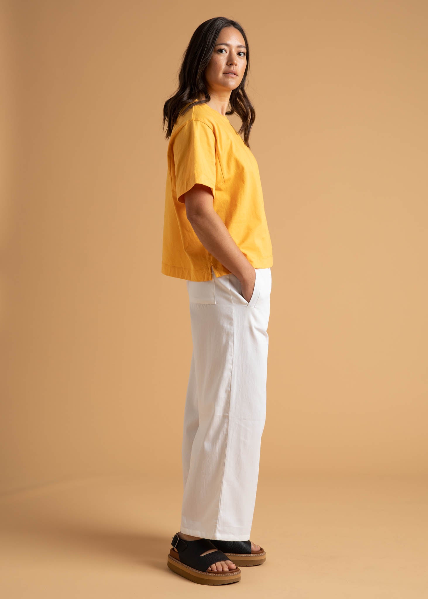 A pair of Shore Pants in Natural color, featuring a modern cropped length, relaxed fit, and elastic waist, displayed on a neutral background.