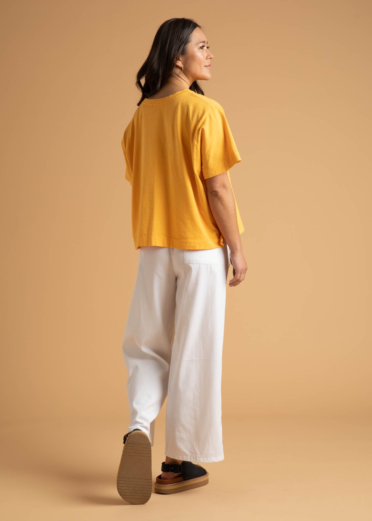 A pair of Shore Pants in Natural color, featuring a modern cropped length, relaxed fit, and elastic waist, displayed on a neutral background.