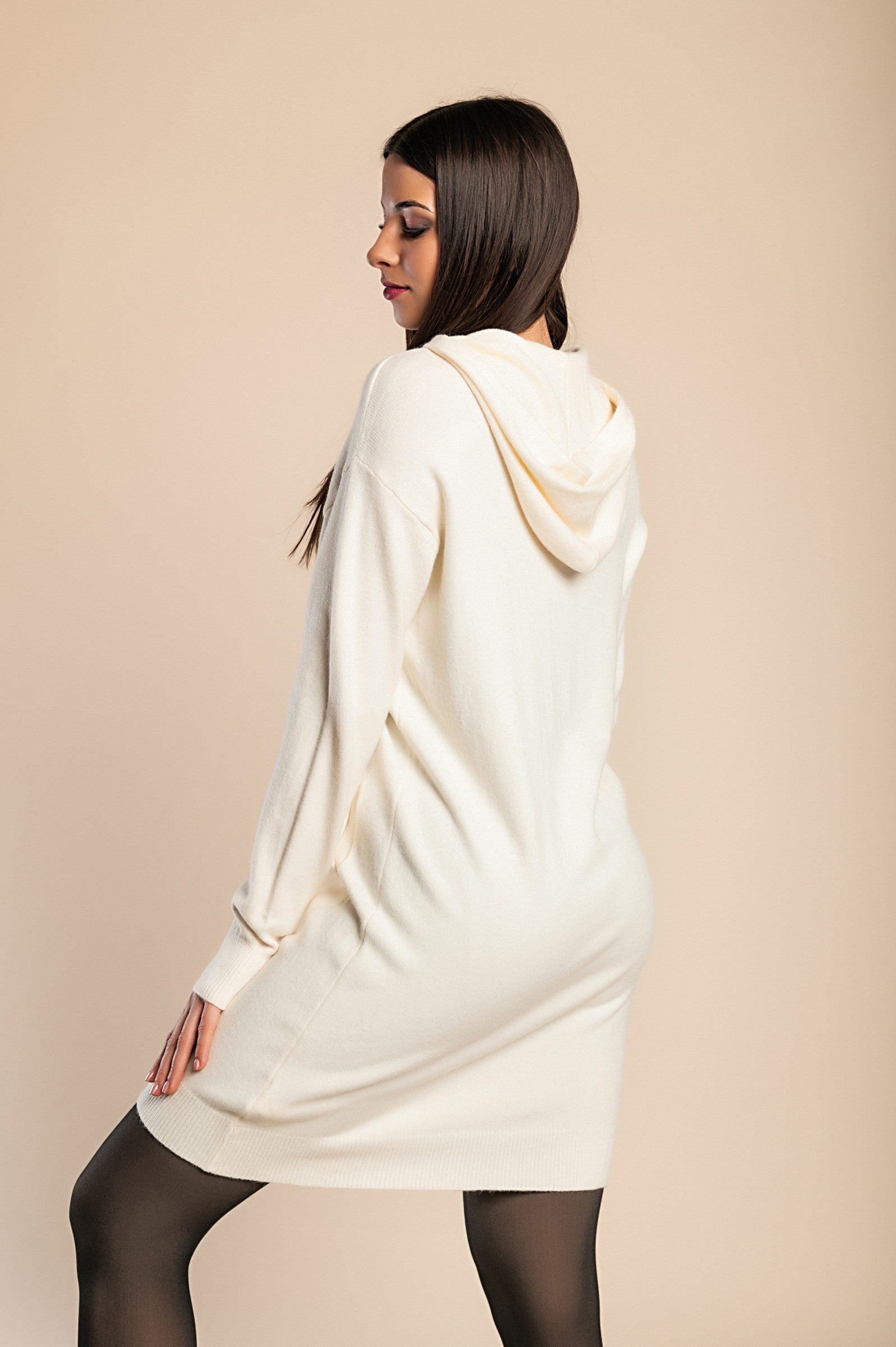 Beige short knitted dress with hood, featuring long sleeves and front pockets, adorned with decorative pearls.