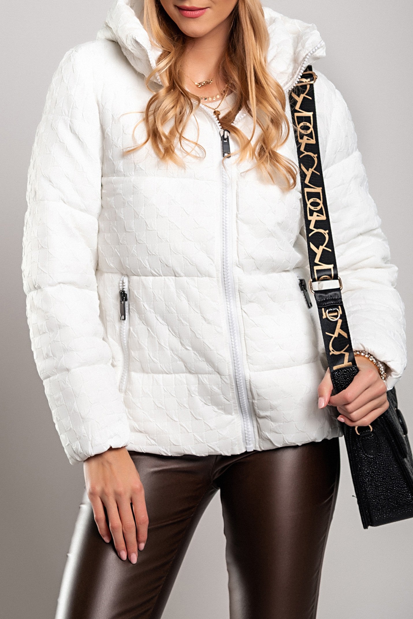 White short padded jacket with hood, featuring a high collar and zipped side pockets, perfect for winter wear.