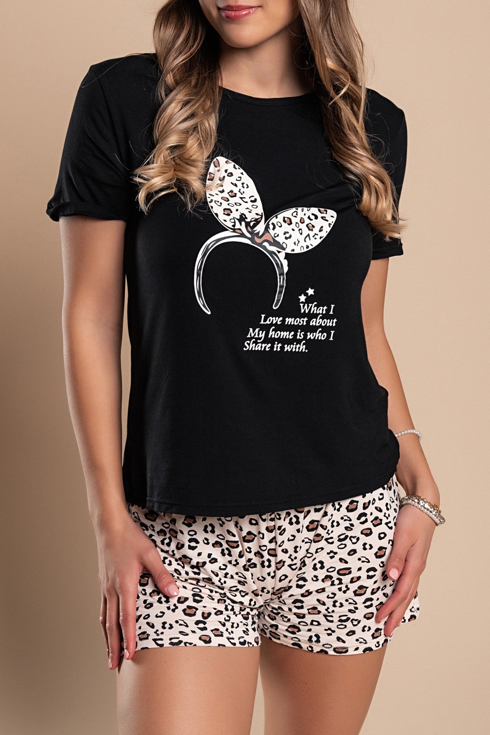 Stylish black short pajamas featuring a trendy print, including a round neck T-shirt and patterned pants with an elastic waist.