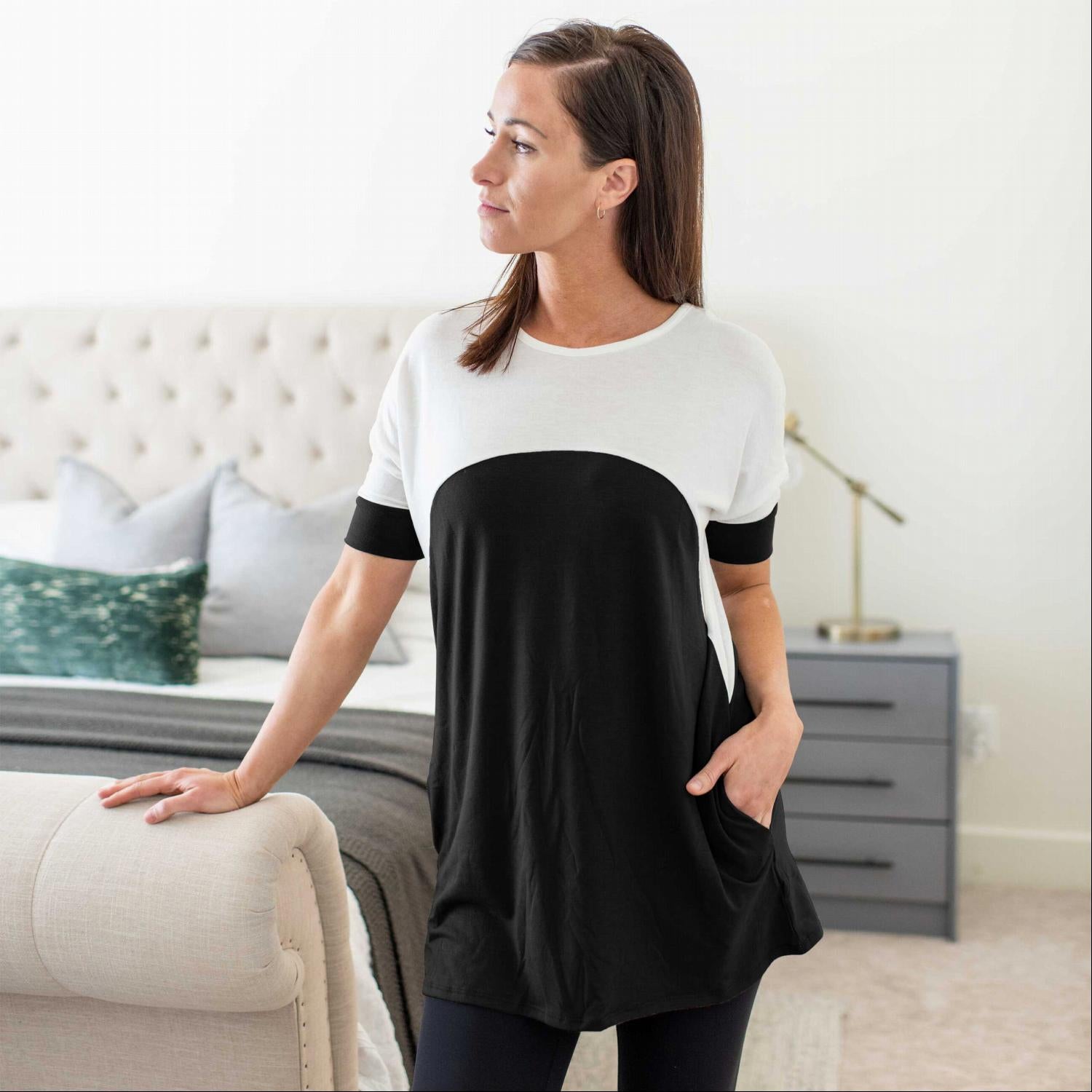 A stylish short sleeve color block tunic top with pockets, featuring a trendy design and soft fabric, perfect for casual wear.