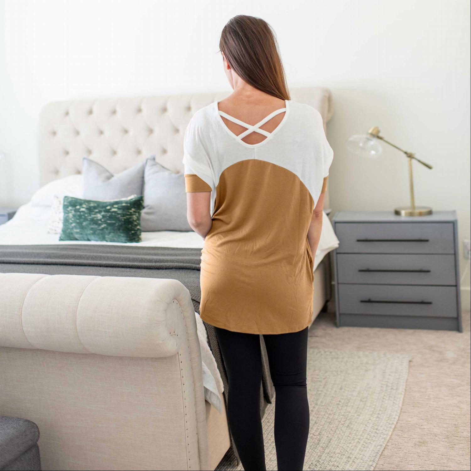 A stylish short sleeve color block tunic top with pockets, featuring a trendy design and soft fabric, perfect for casual wear.