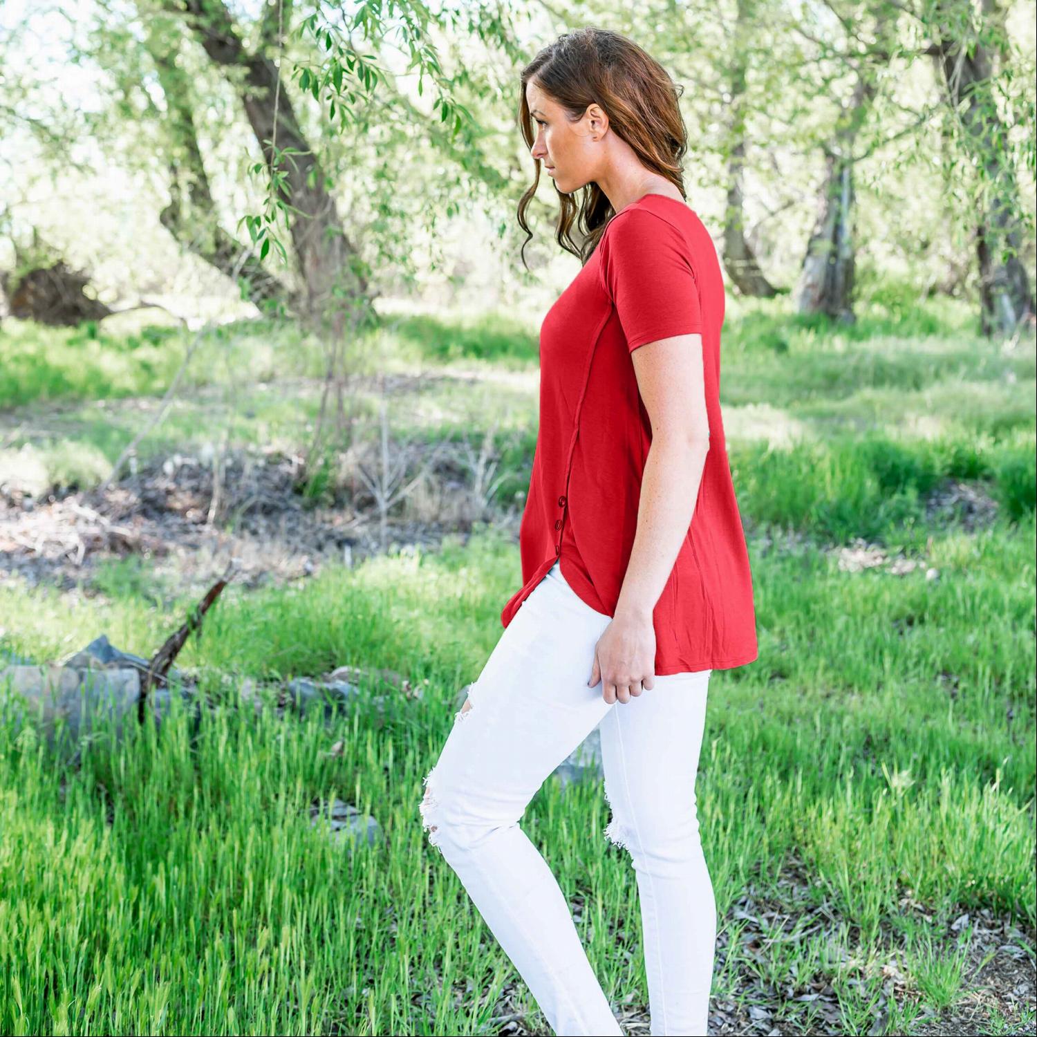 A stylish loose-fitting short sleeve top with a modest scoop neck, rounded hemline, and decorative side buttons, perfect for casual wear.