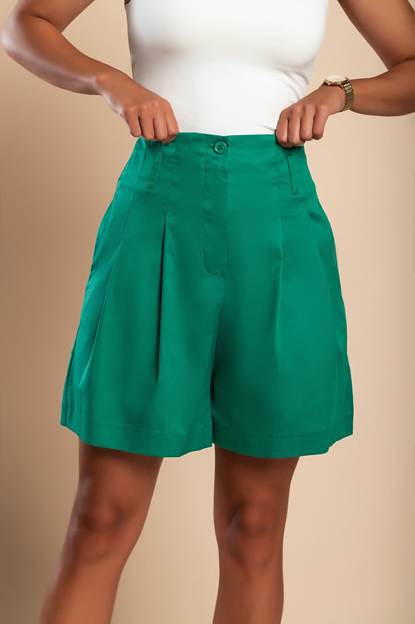 High waist green shorts made of soft cotton, featuring a loose fit and button and zipper closure, perfect for summer wear.