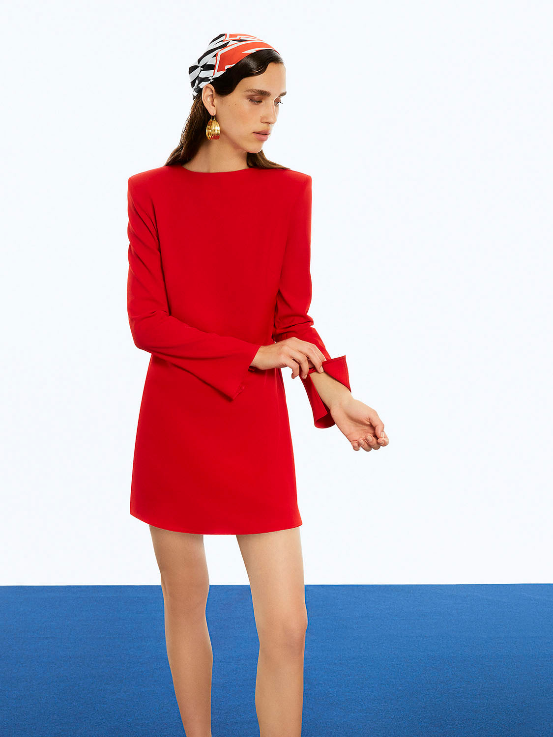 A stylish Shoulder Pad Mini Dress featuring a crew-neck, long slit sleeves, and a bold monochrome pattern with vibrant red and fuchsia accents.