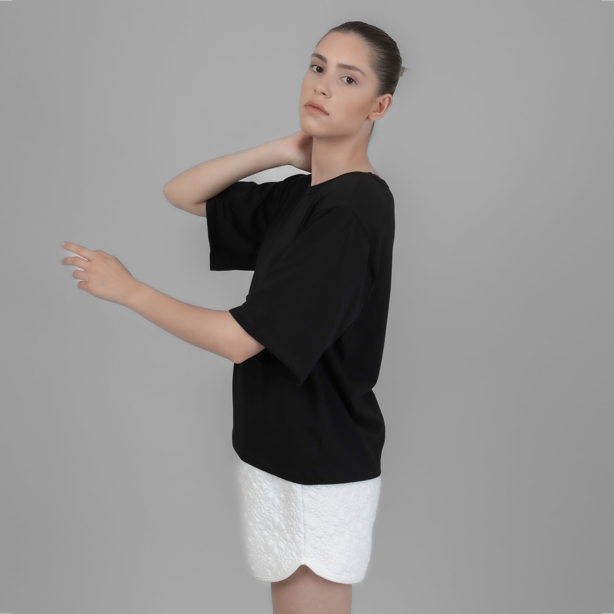 Black Shoulder Pad T-shirt displayed on a model, showcasing its elegant design and comfortable fit.