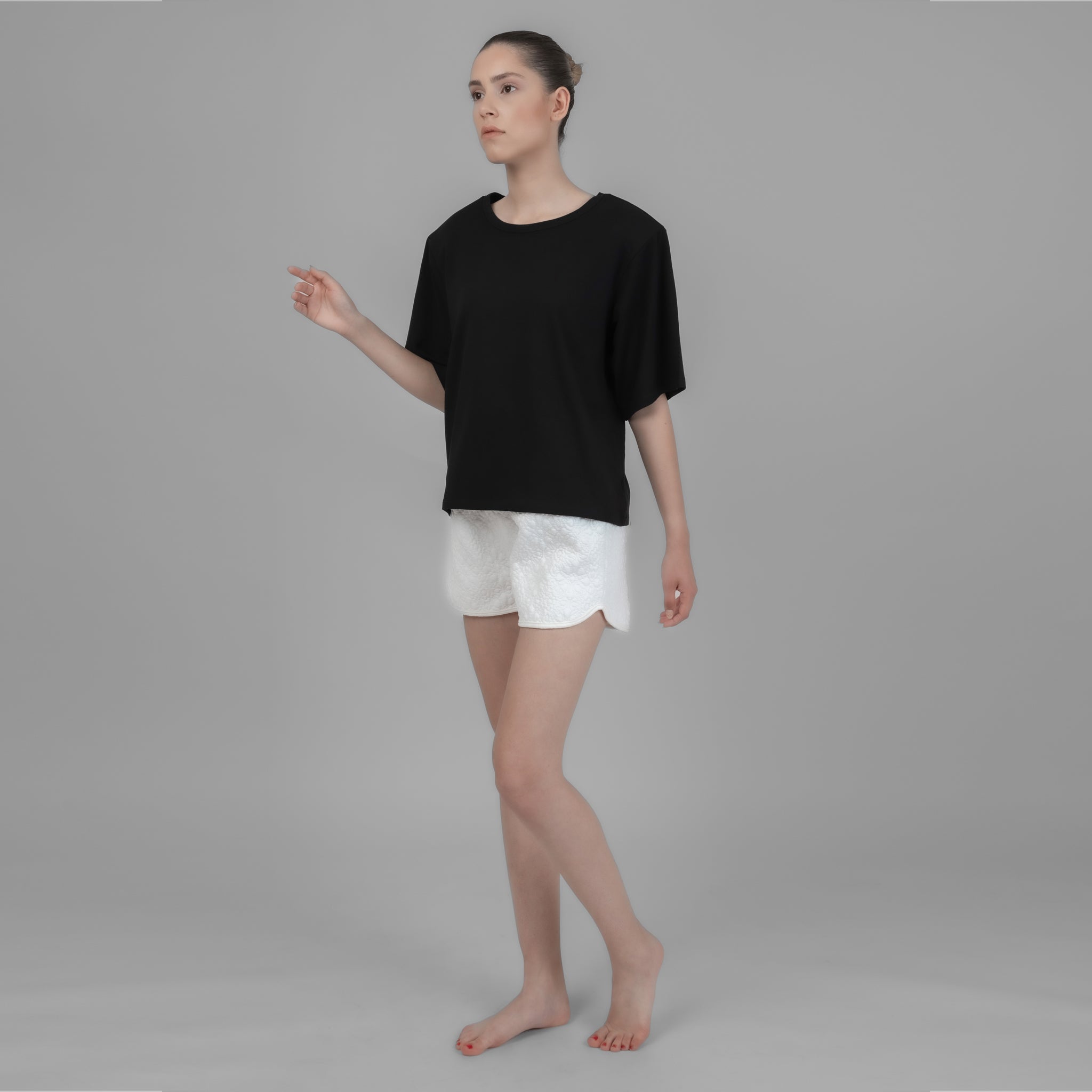 Black Shoulder Pad T-shirt displayed on a model, showcasing its elegant design and comfortable fit.