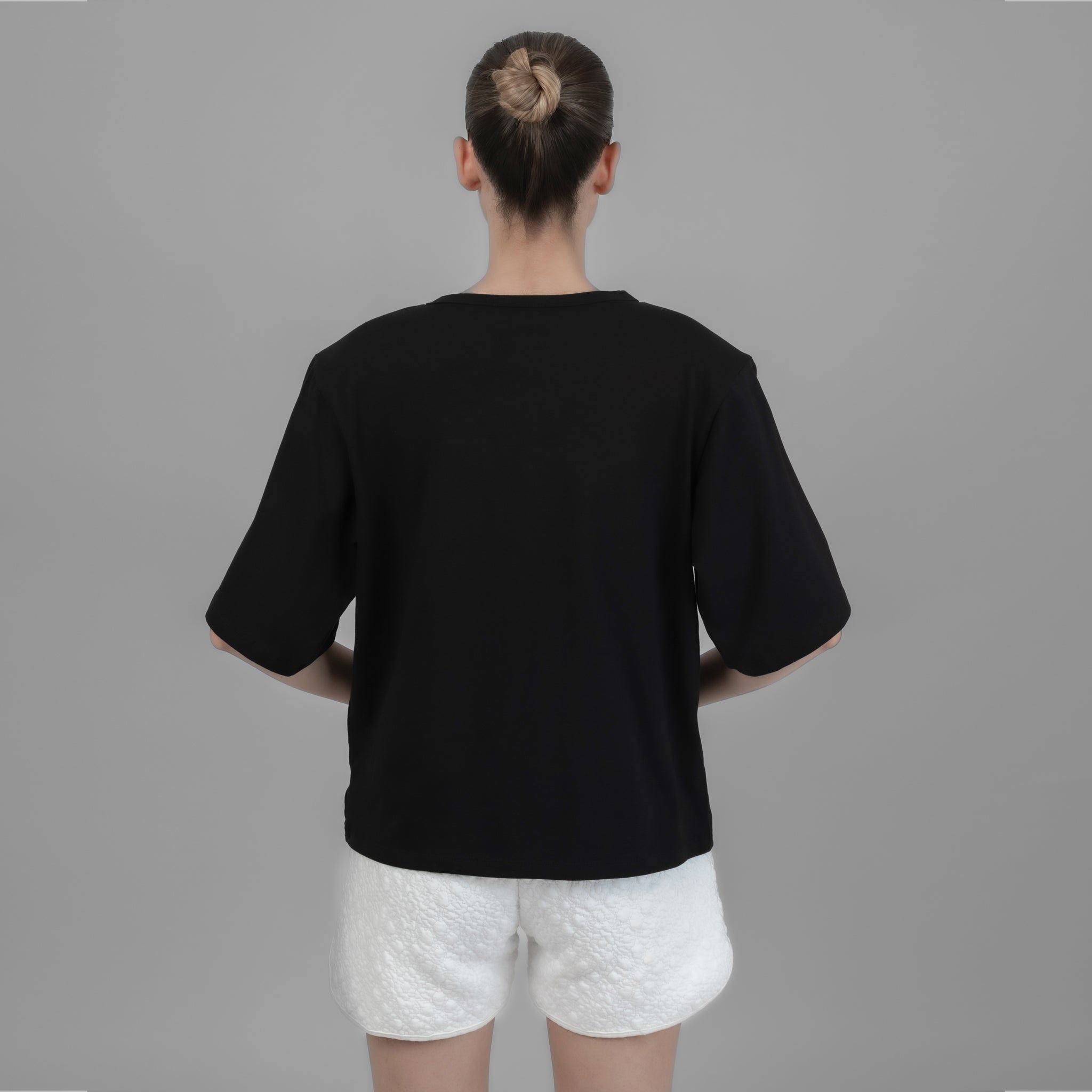 Black Shoulder Pad T-shirt displayed on a model, showcasing its elegant design and comfortable fit.