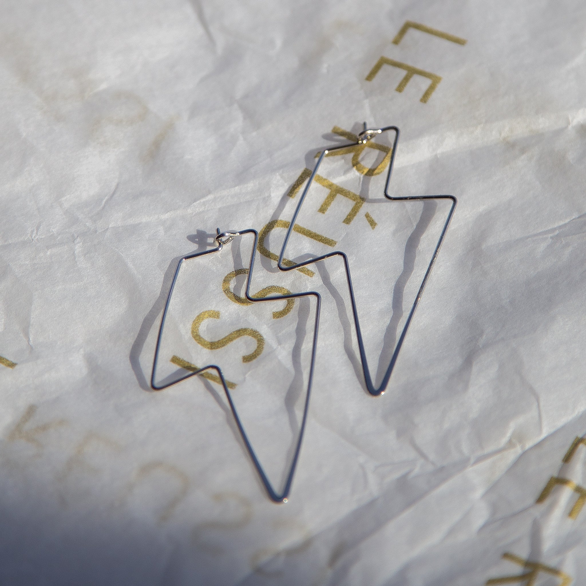 A pair of elegant silver earrings shaped like lightning bolts, showcasing intricate Italian craftsmanship.