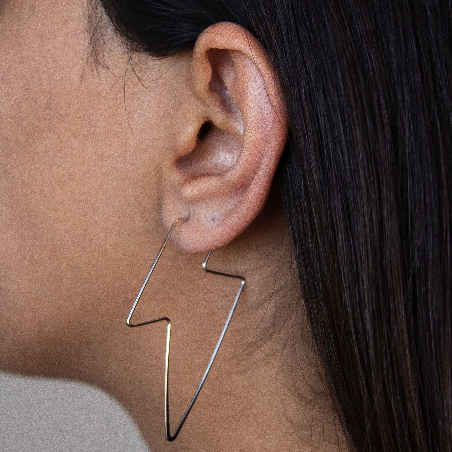 A pair of elegant silver earrings shaped like lightning bolts, showcasing intricate Italian craftsmanship.